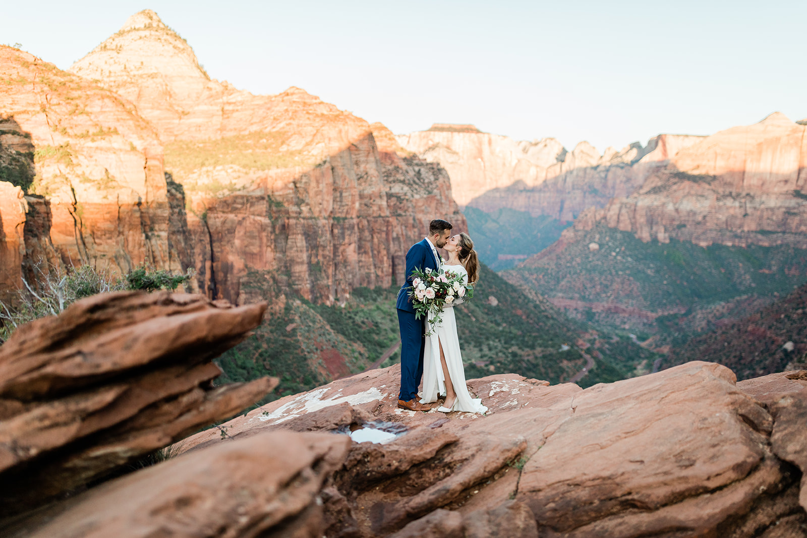 couple kiss overlooking Zion National Park before wedding ceremony