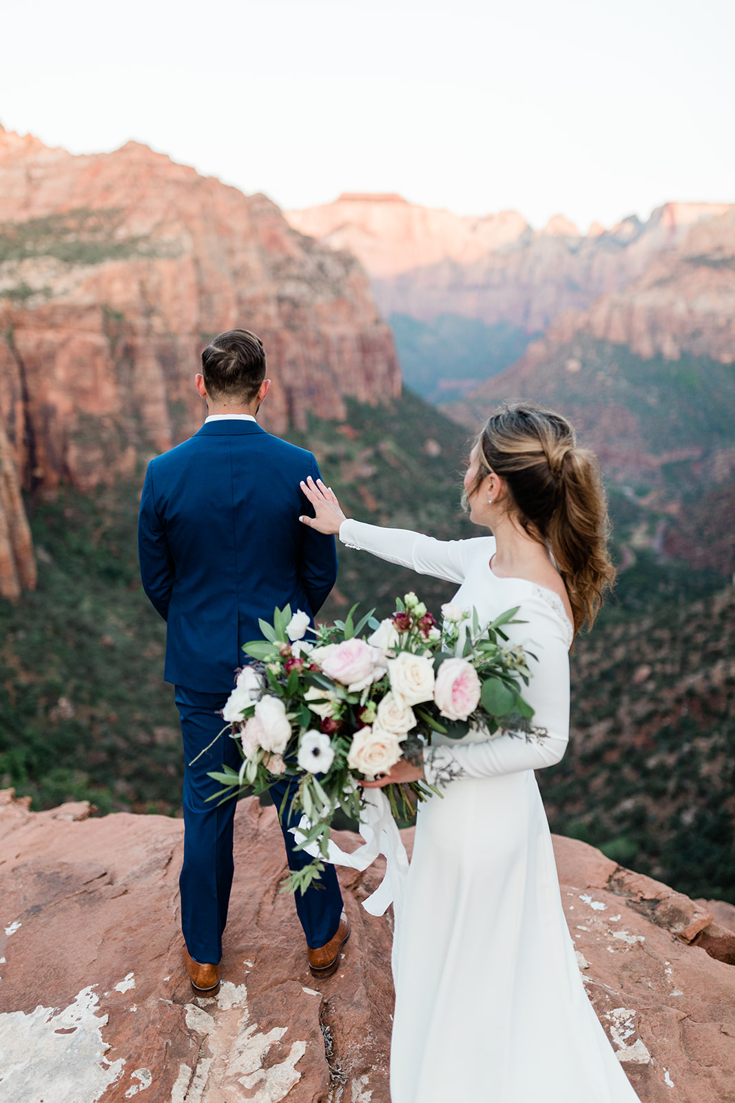 bride makes her way up mountain in Zion National Park for first look
