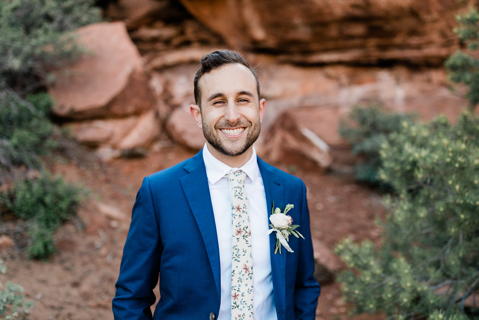 groom with floral tie and boutonniere