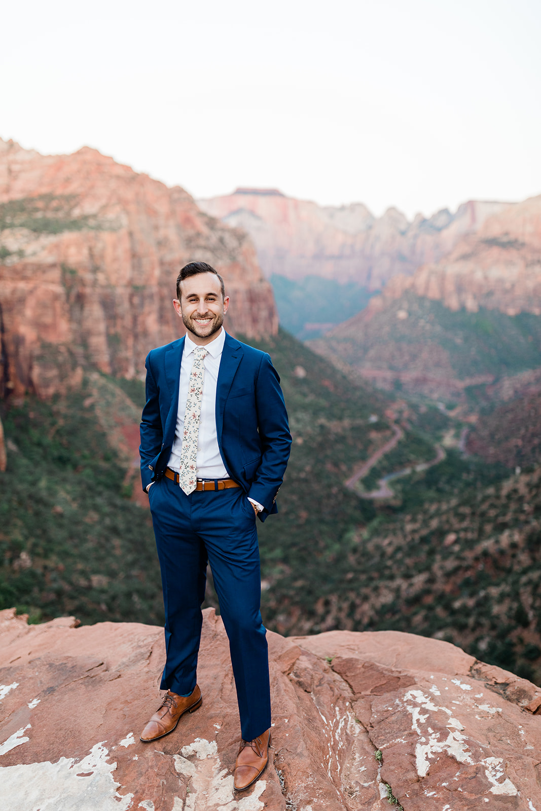 groom standing in front of stunning Zion National Park vista