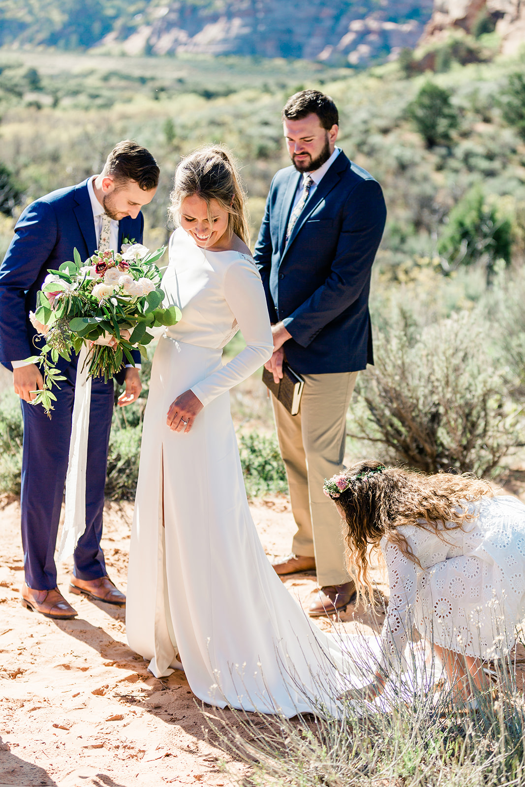 flower girl spreads out bride's dress for elopement ceremony