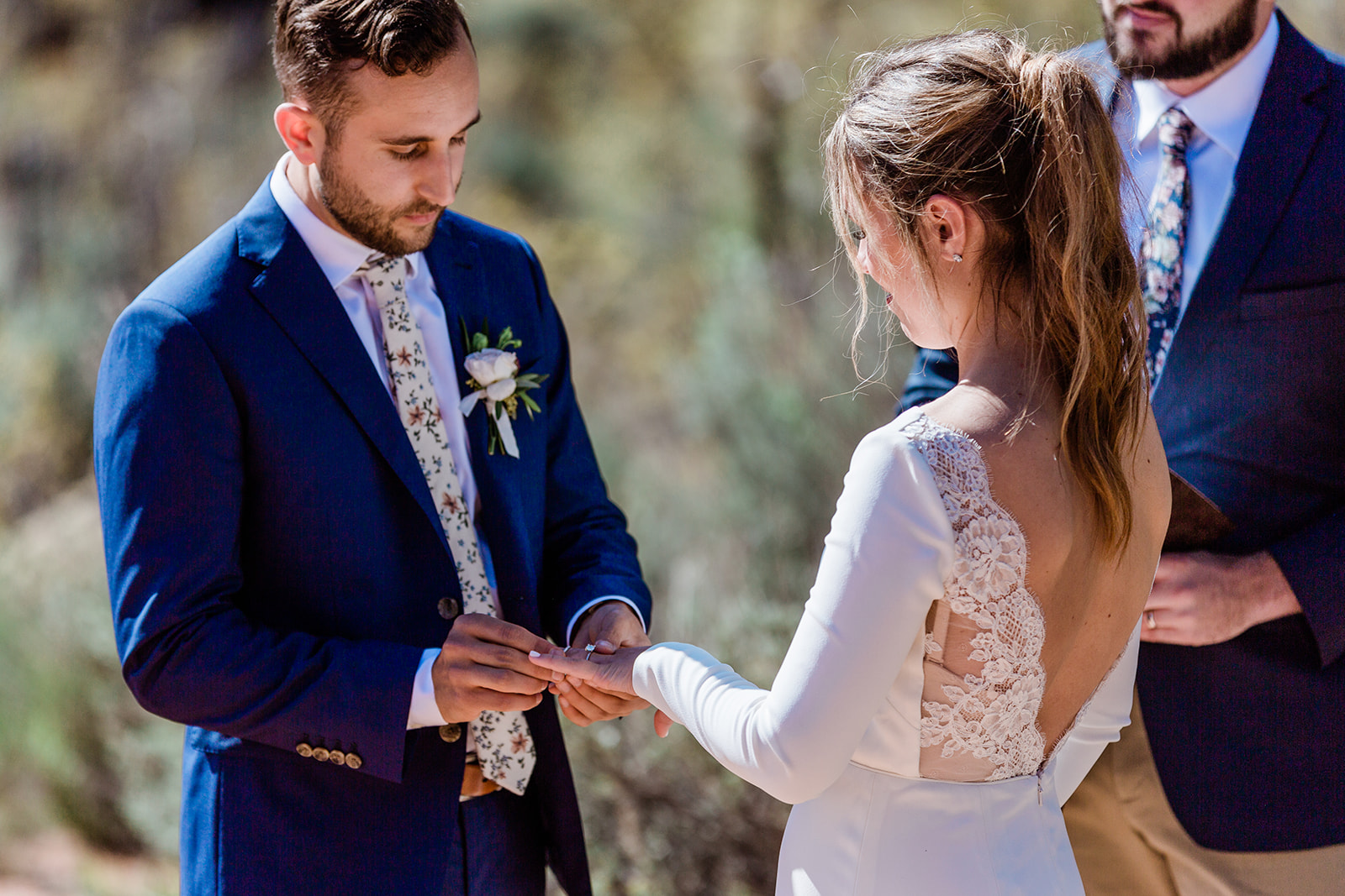 groom puts ring on bride's hand