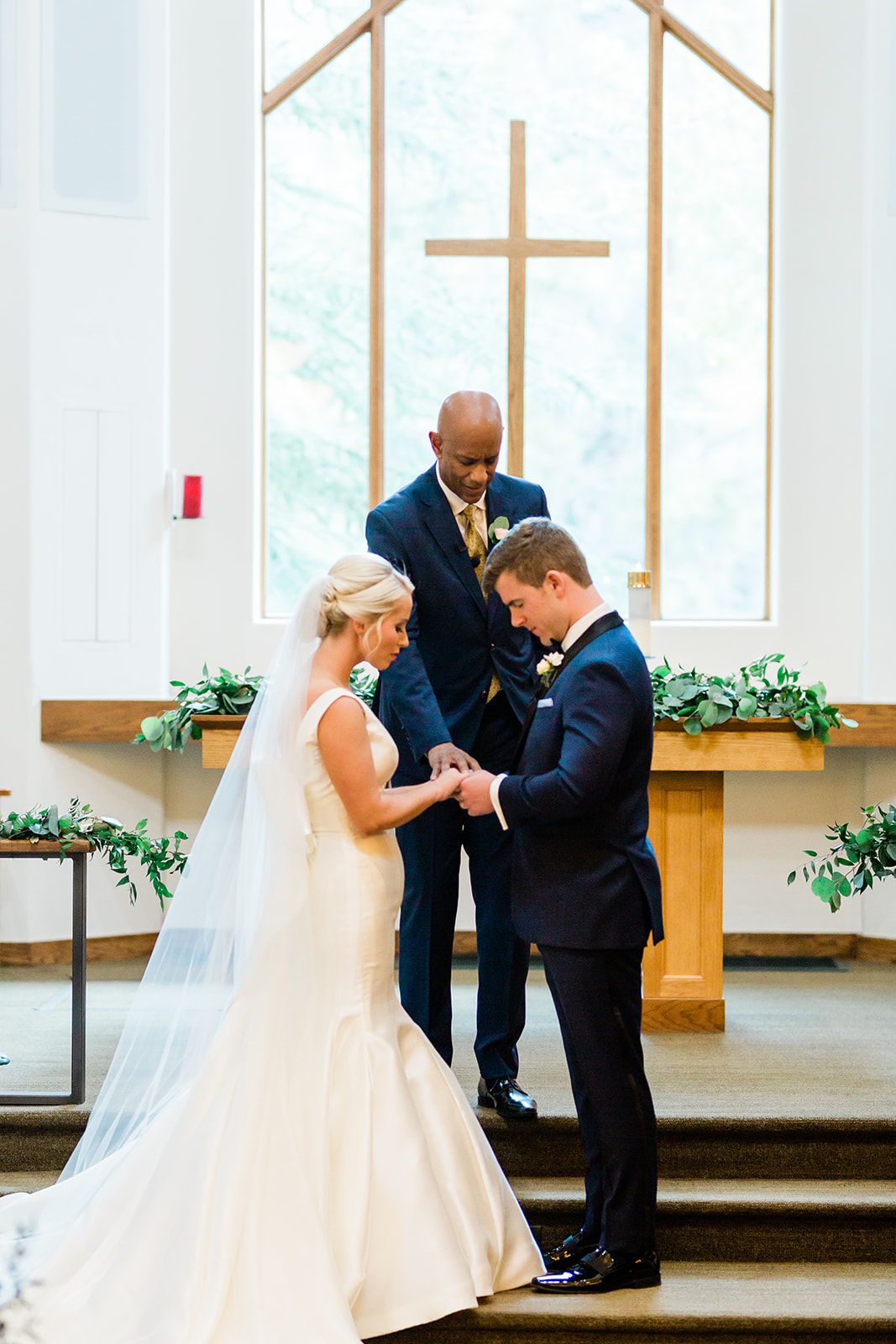 officiant blesses bride and groom in Vail church during wedding ceremony