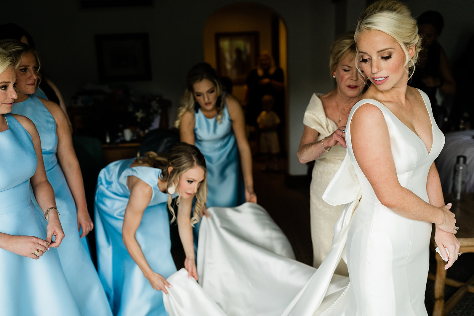 bridesmaids help bride get dressed in wedding dress the morning of her Vail wedding