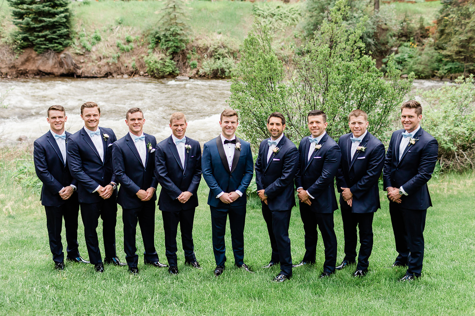 groom and groomsmen portrait by river in Colorado mountains