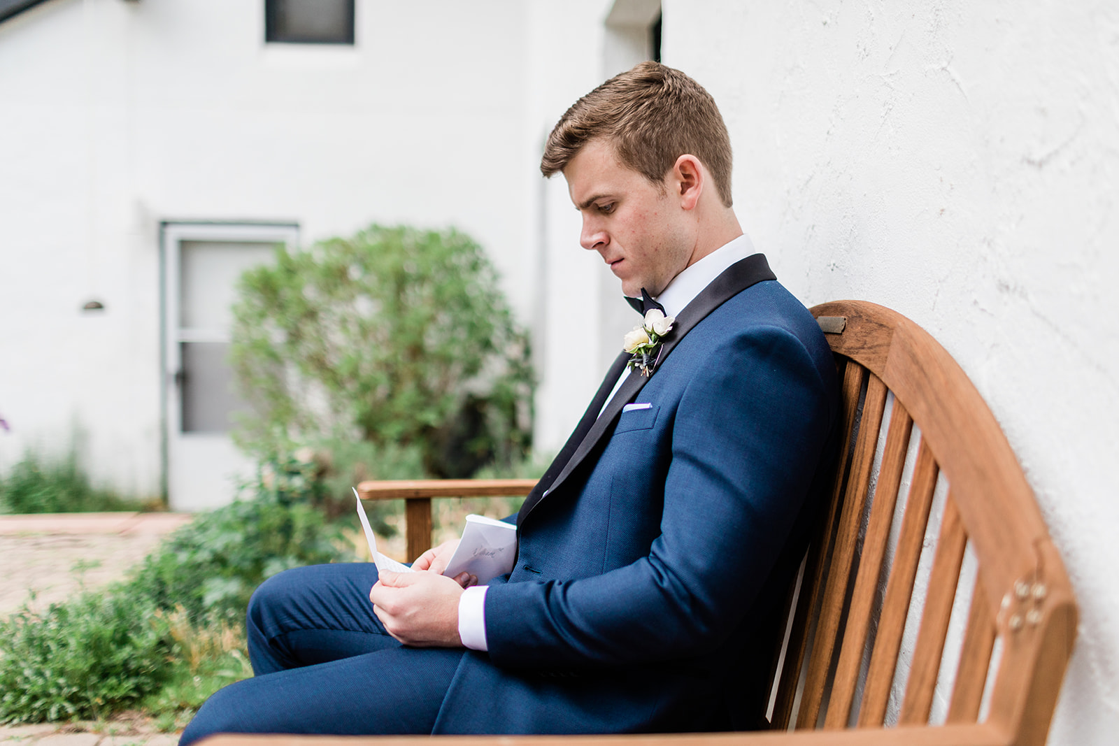 groom reading note from bride before wedding ceremony