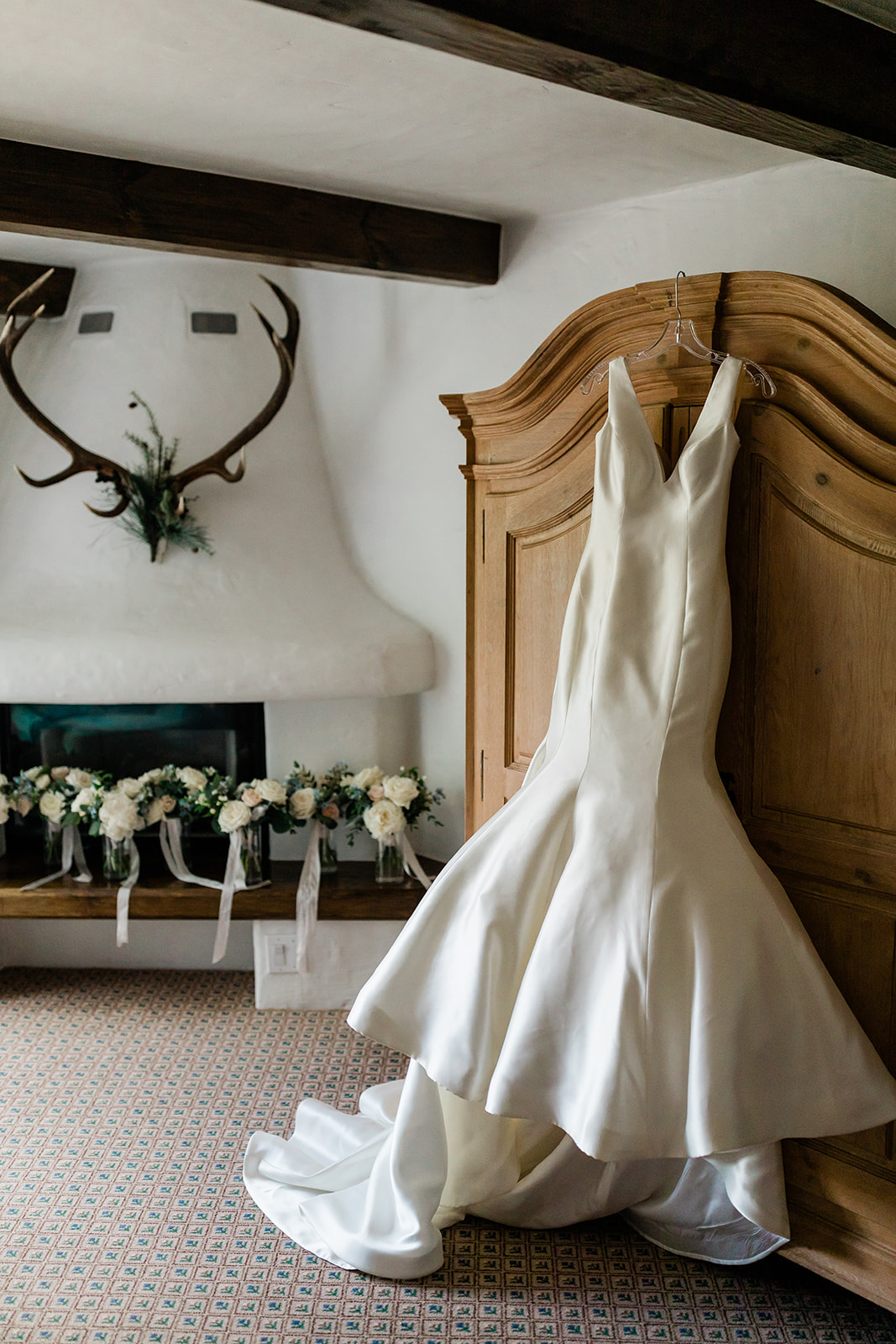 beautiful designer wedding dress hanging in Vail ready room