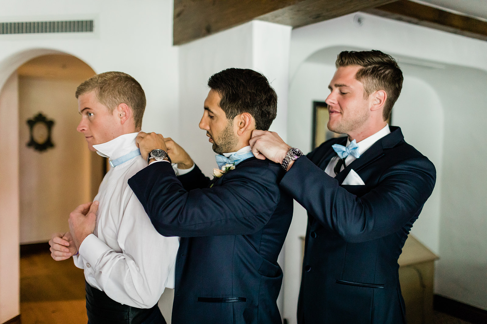 groomsmen help each other get ready for Vail wedding