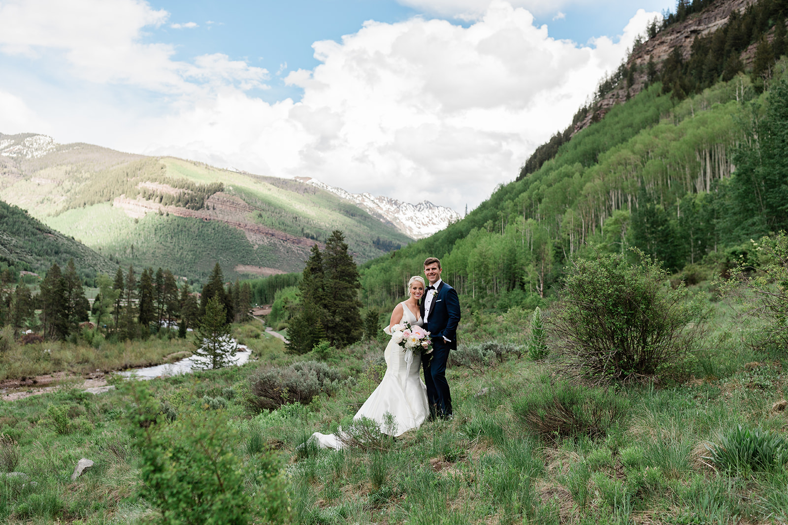 bride and groom walking through Vail mountains