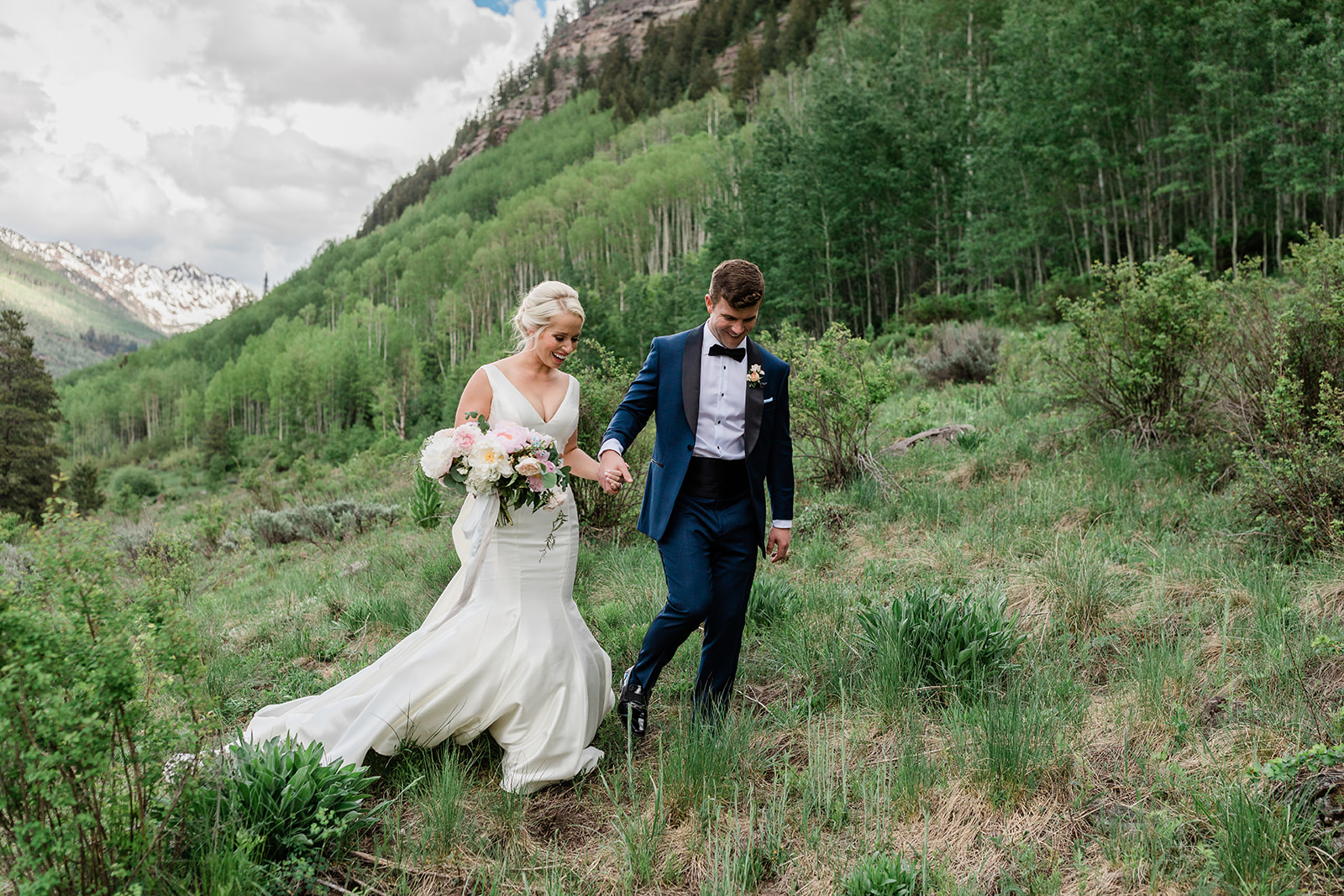 bride and groom walking through Vail mountains