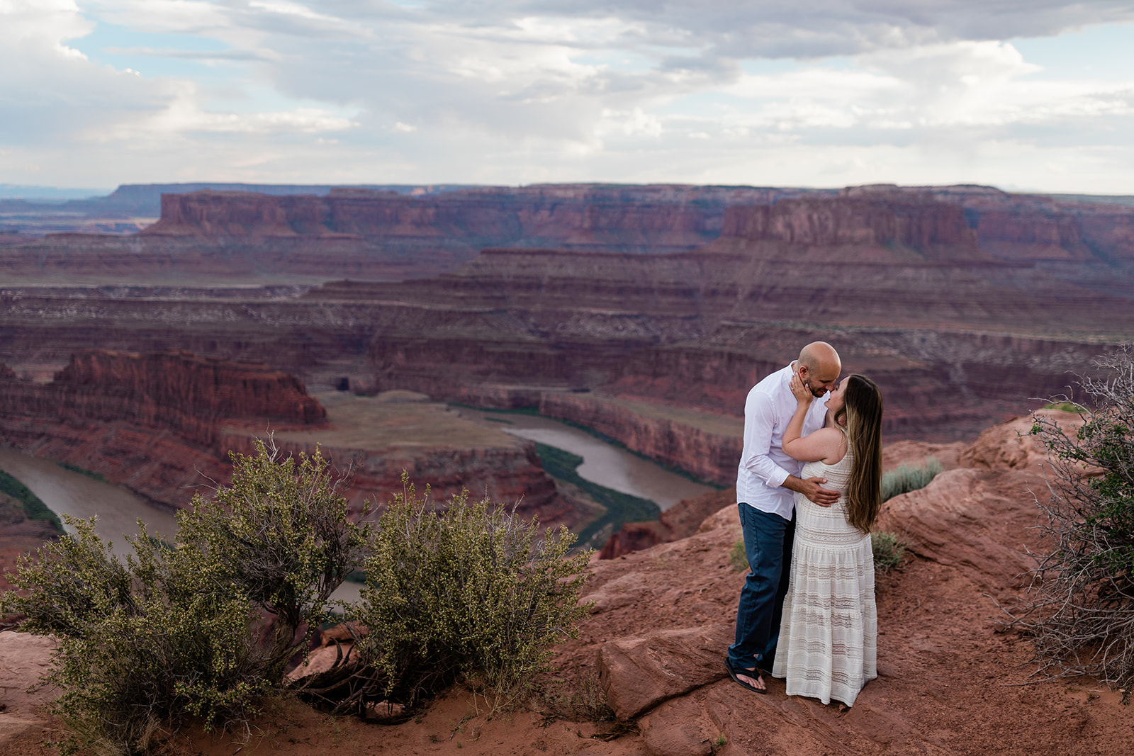 couple kisses in Moab dessert during Adventure Session with Hazel and Lace Photography