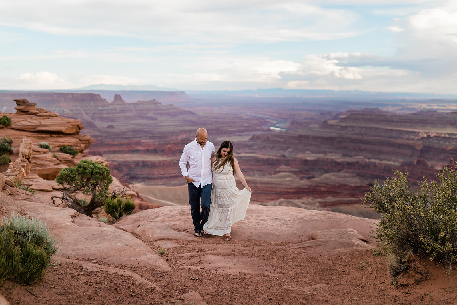 couple stands on top of Moab bluff for adventure photography session