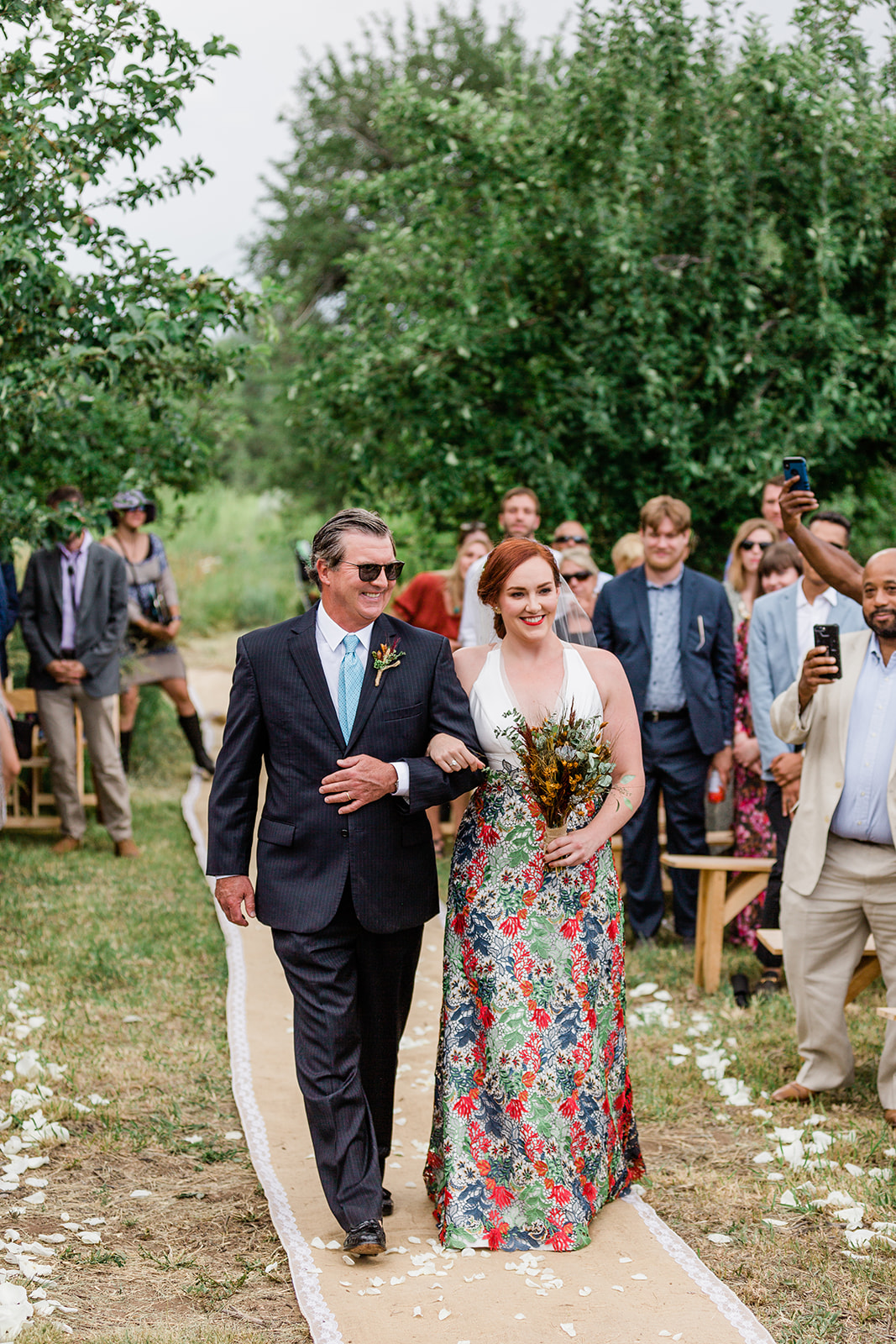 bride walks down aisle in outdoor Taos wedding ceremony