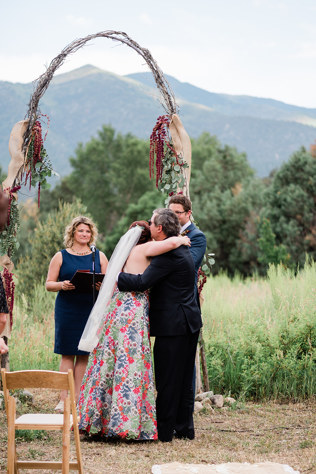 bride walks down aisle in outdoor Taos wedding ceremony