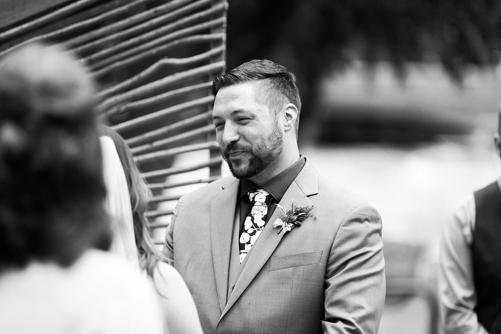 groom smiles at bride during vows