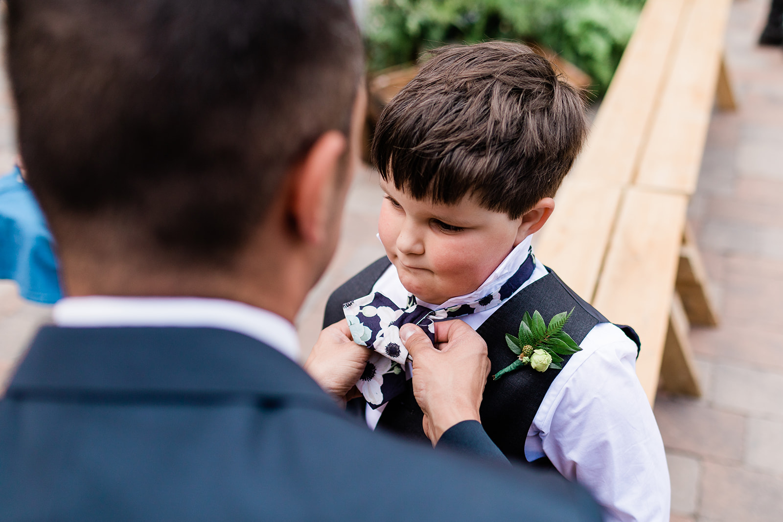 groom helps ring bearer put tie on