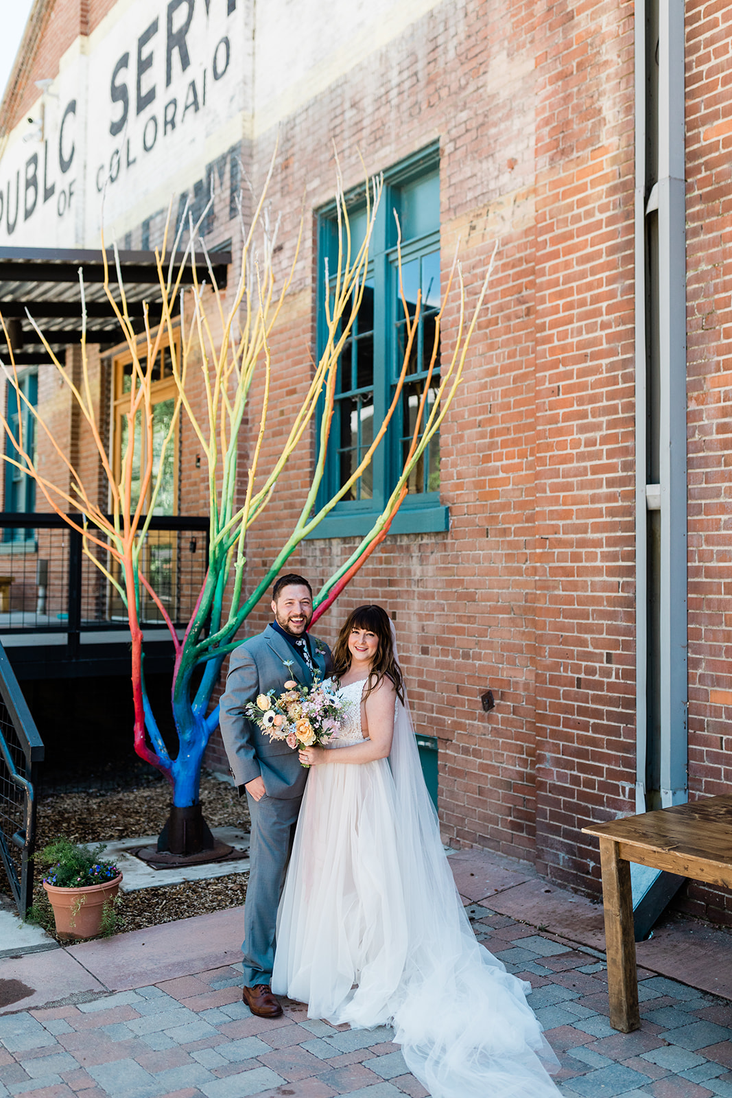 bride and groom pose in front of historic Salida building