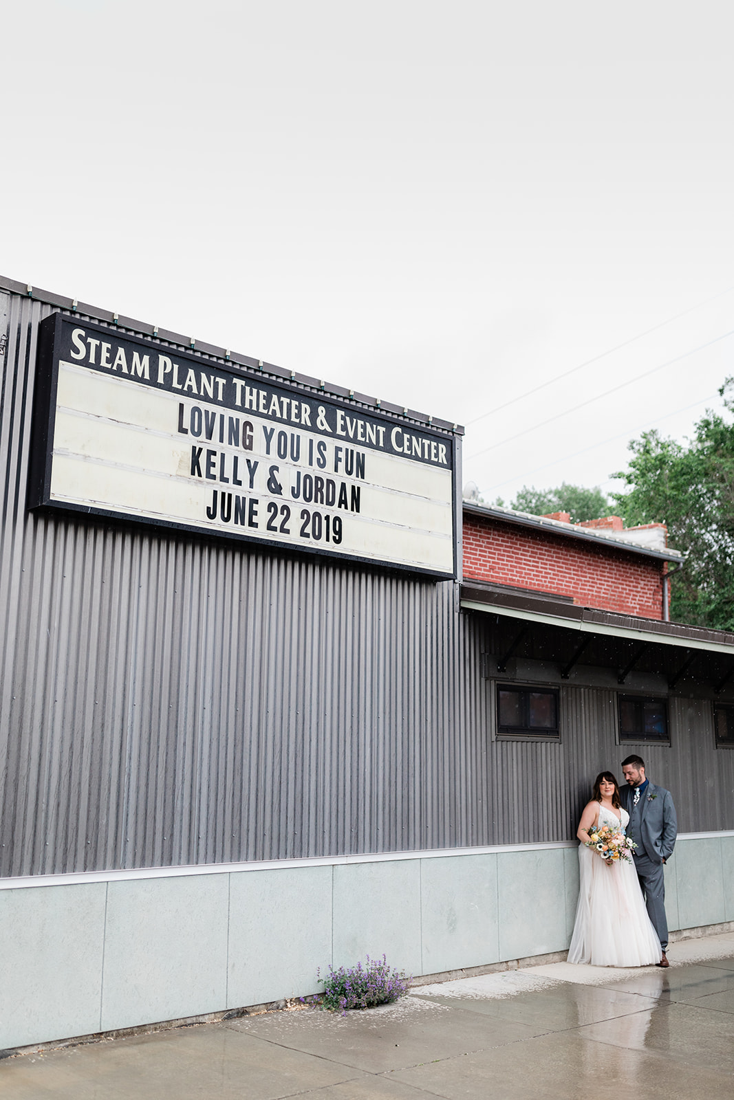 bride and groom posing under personalized marquee at wedding