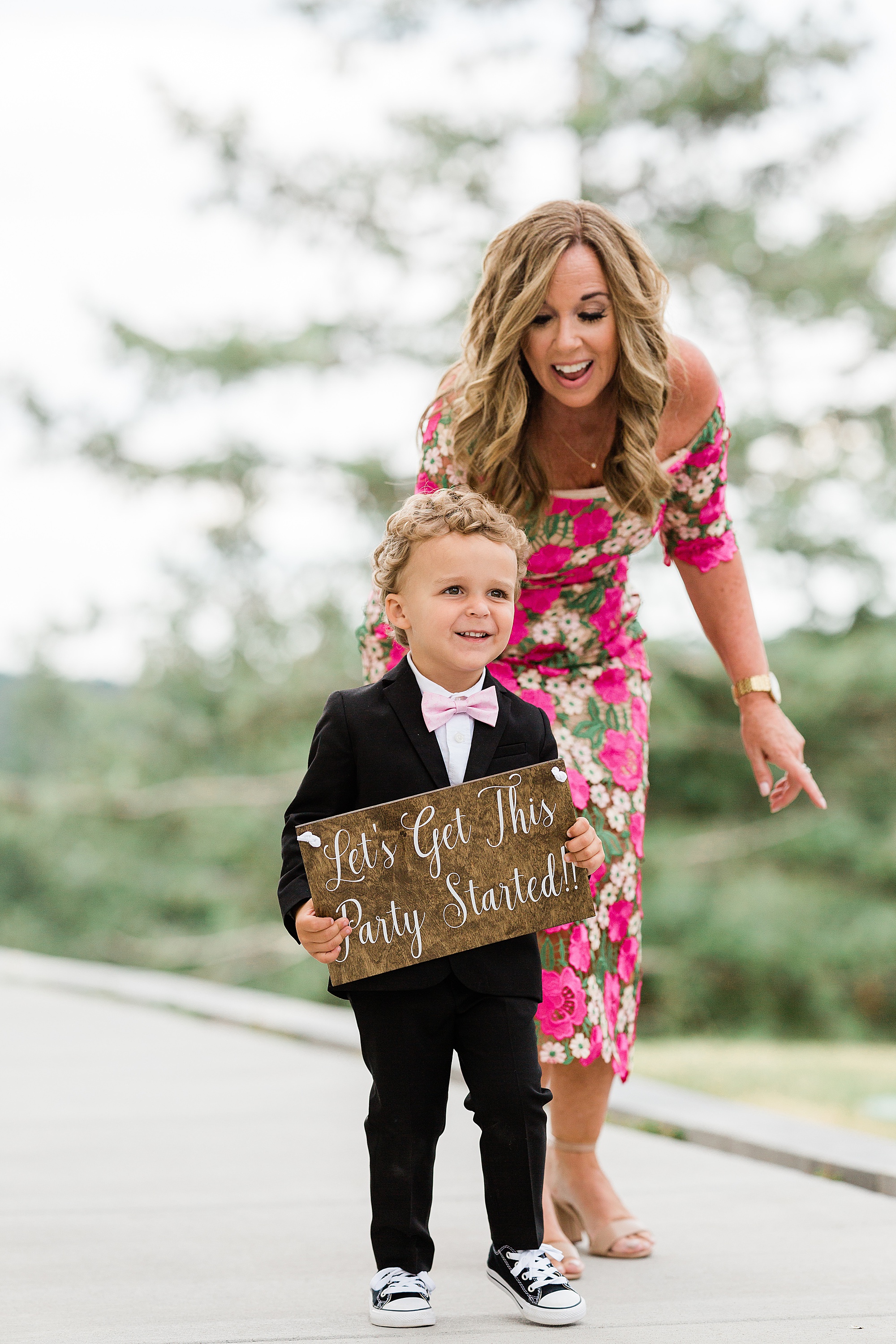 ring bearer with sign that says let's get this party started