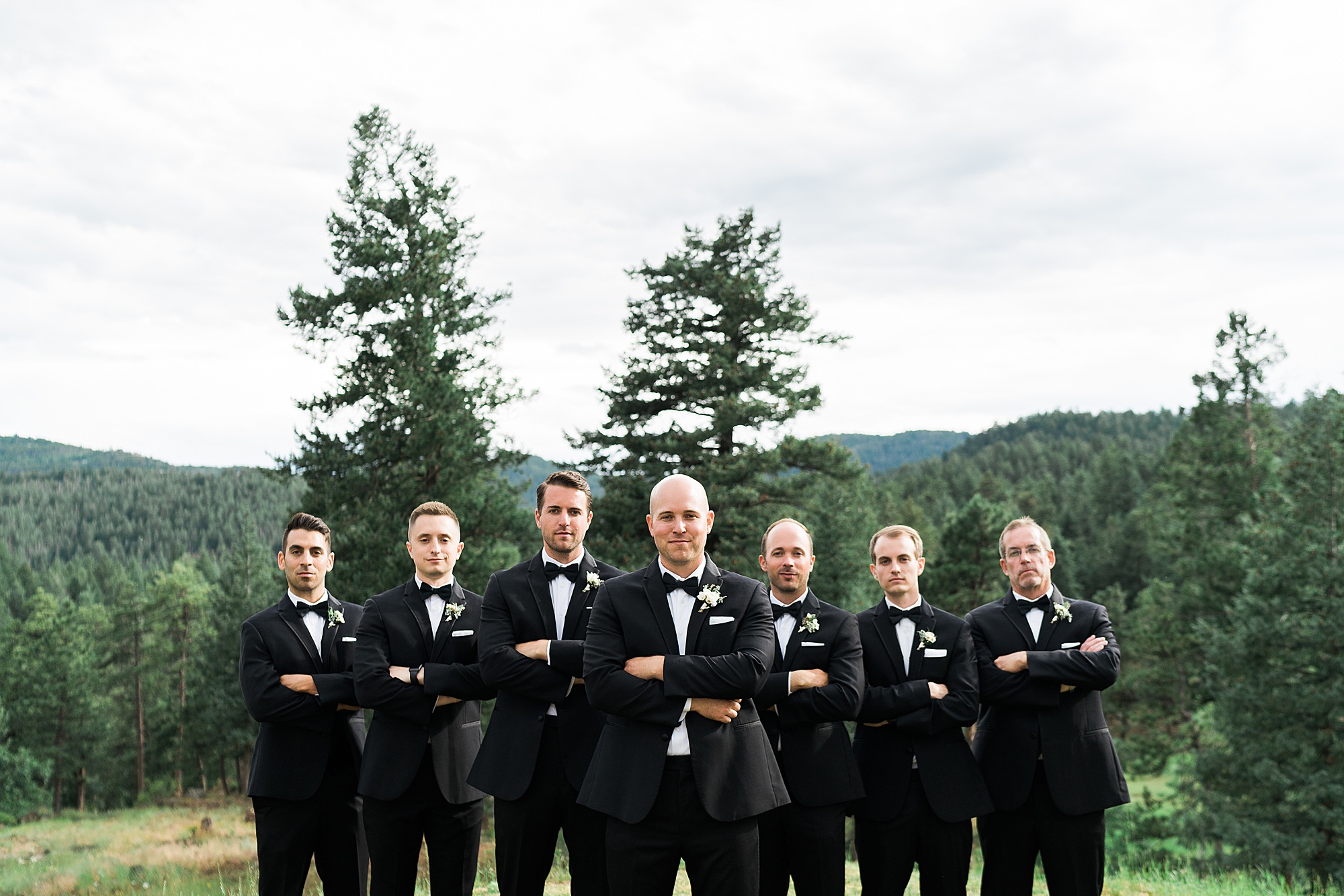 serious groomsmen portrait in the mountains