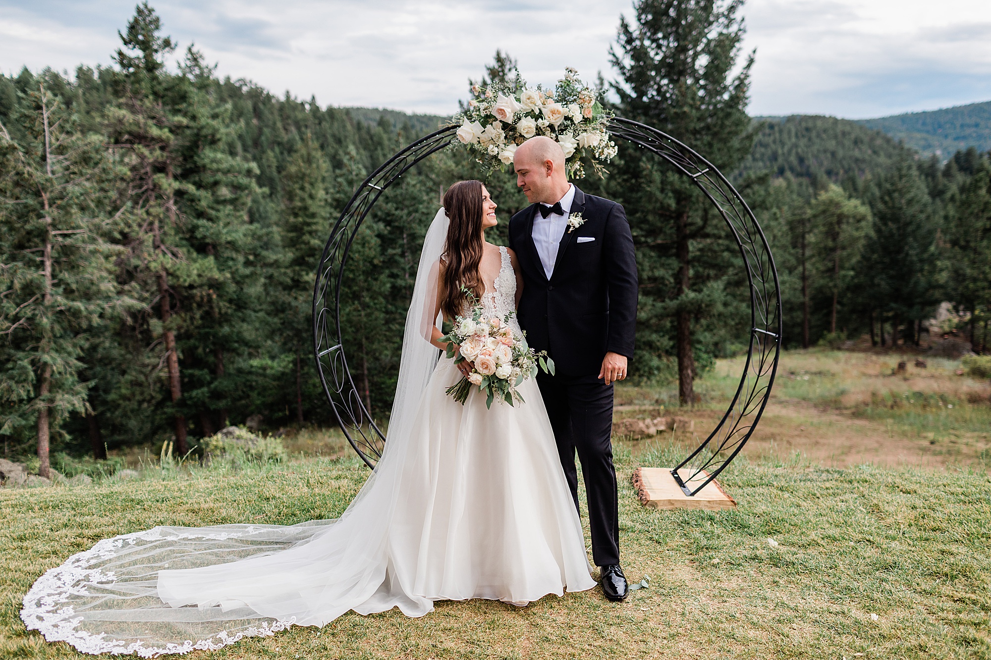 bride and groom portrait at ceremony arch in the mountains