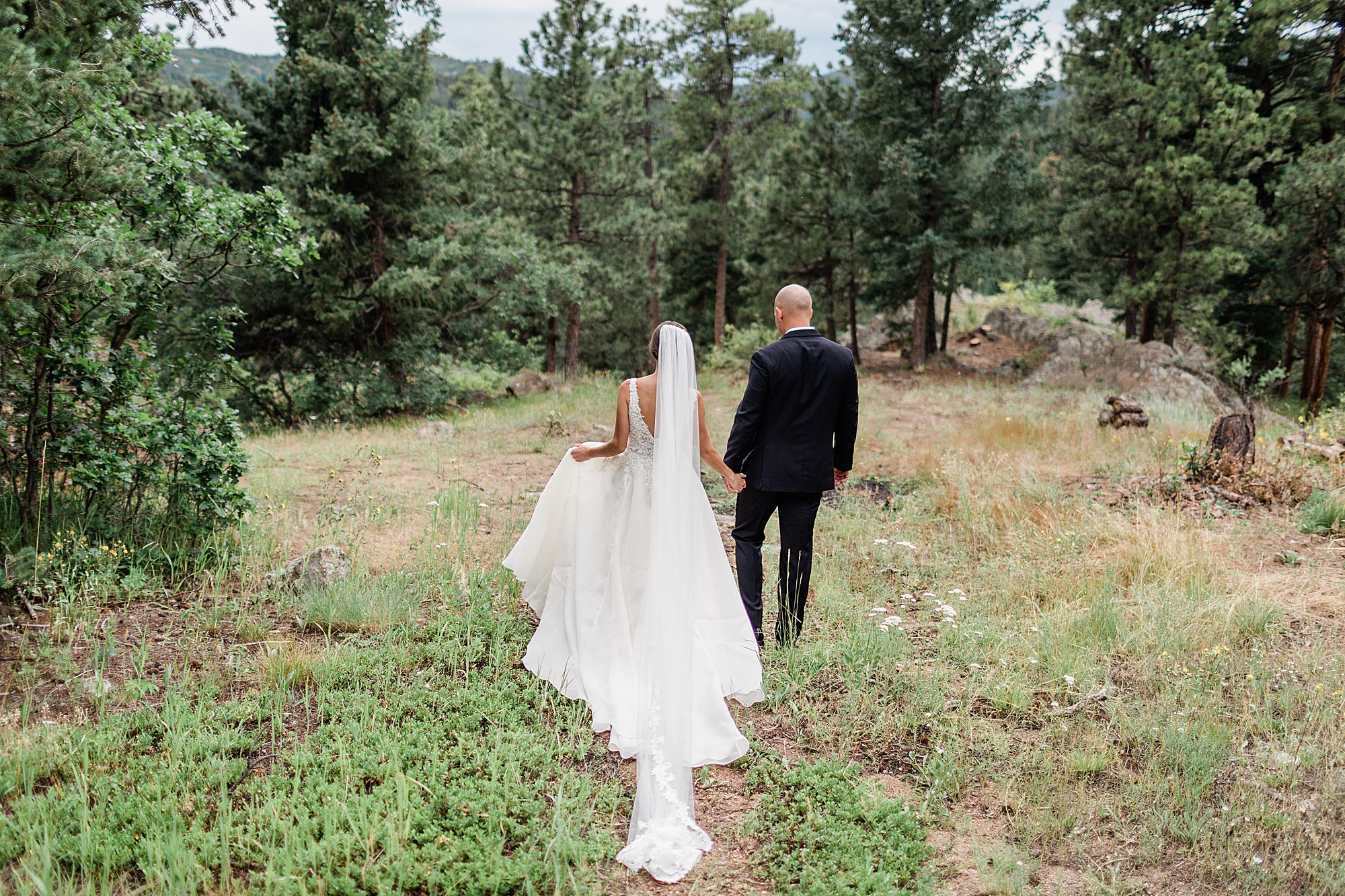 bride and groom walking in the mountains