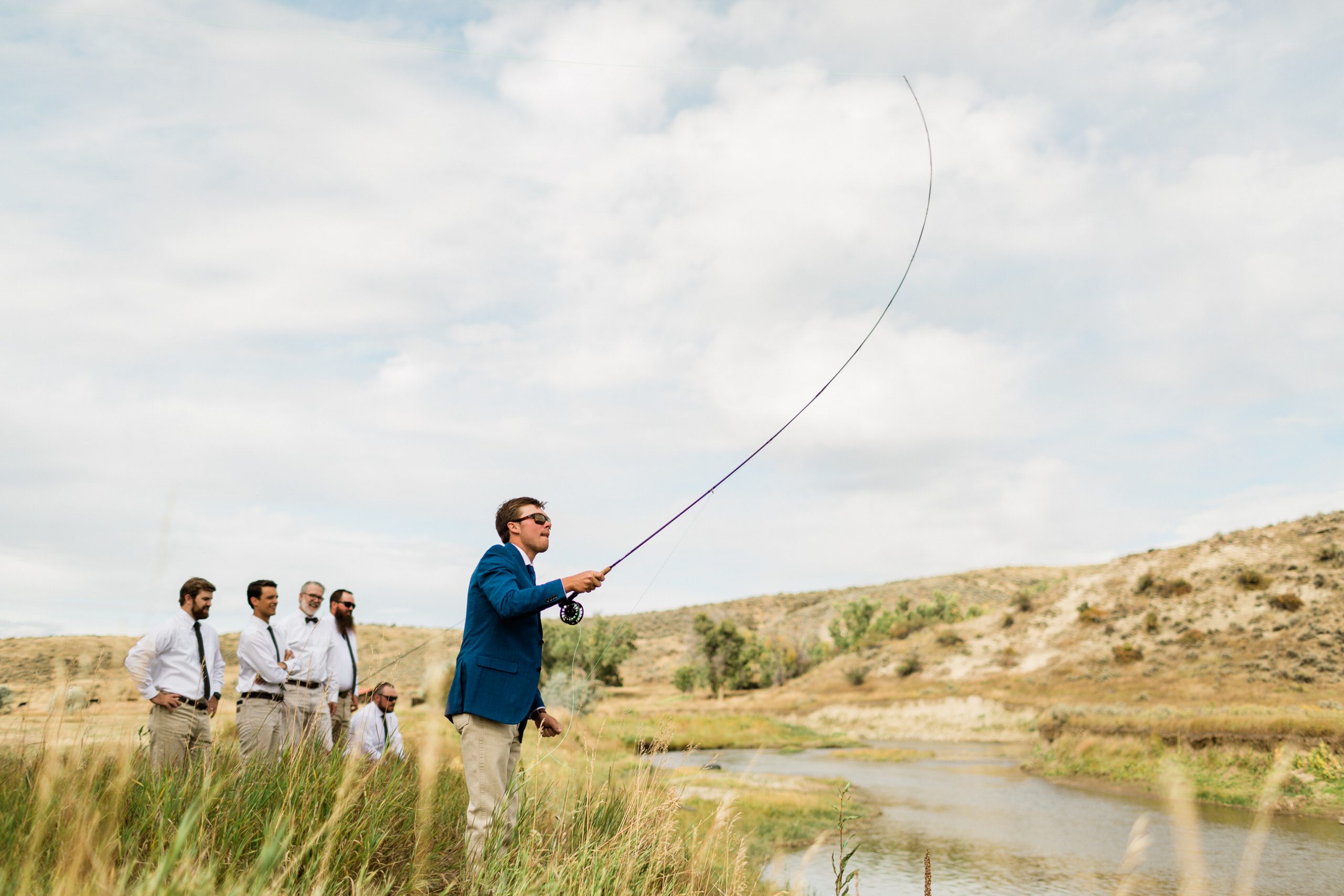 groom portrait fly fishing at river