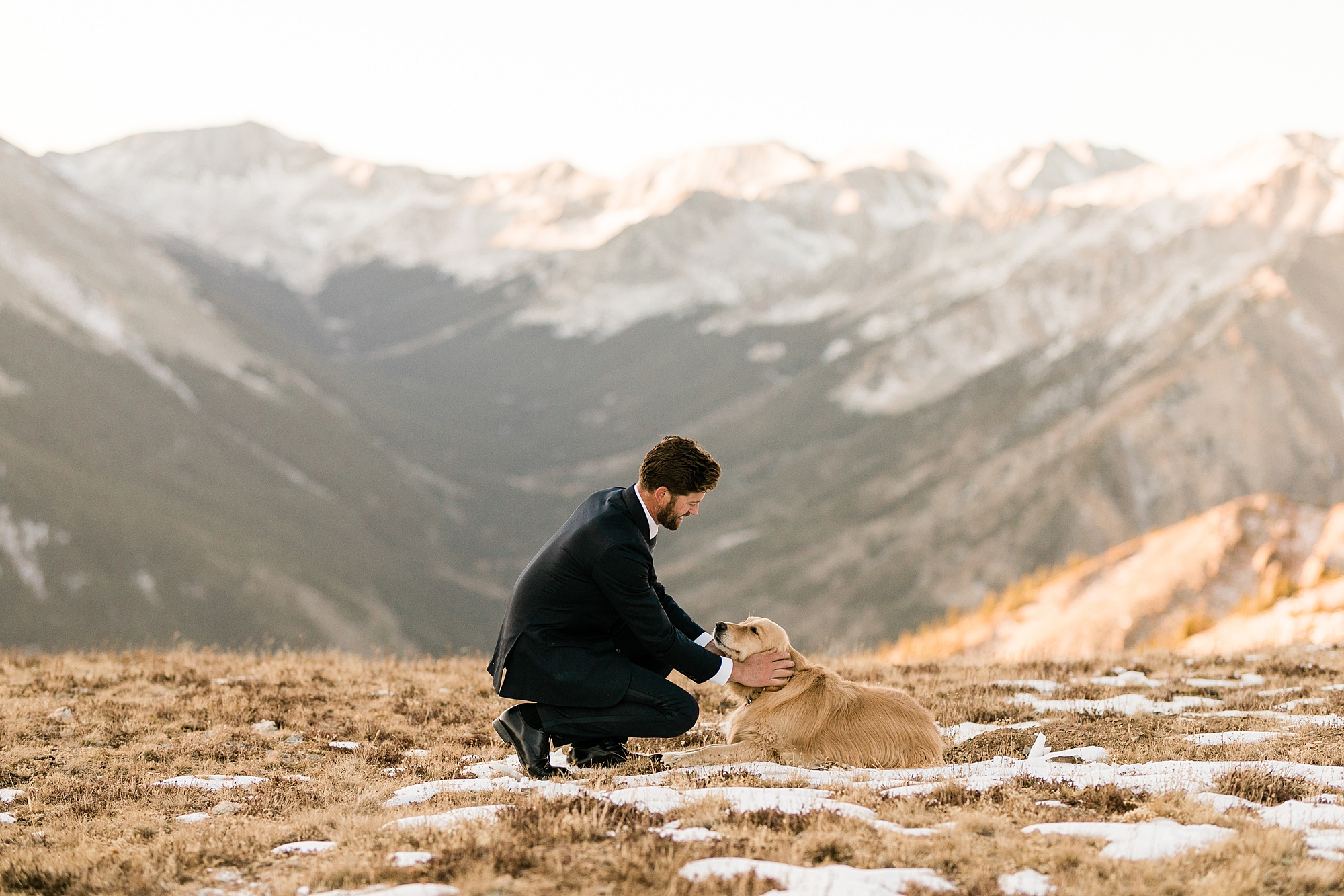 groom with his dog on mountain top