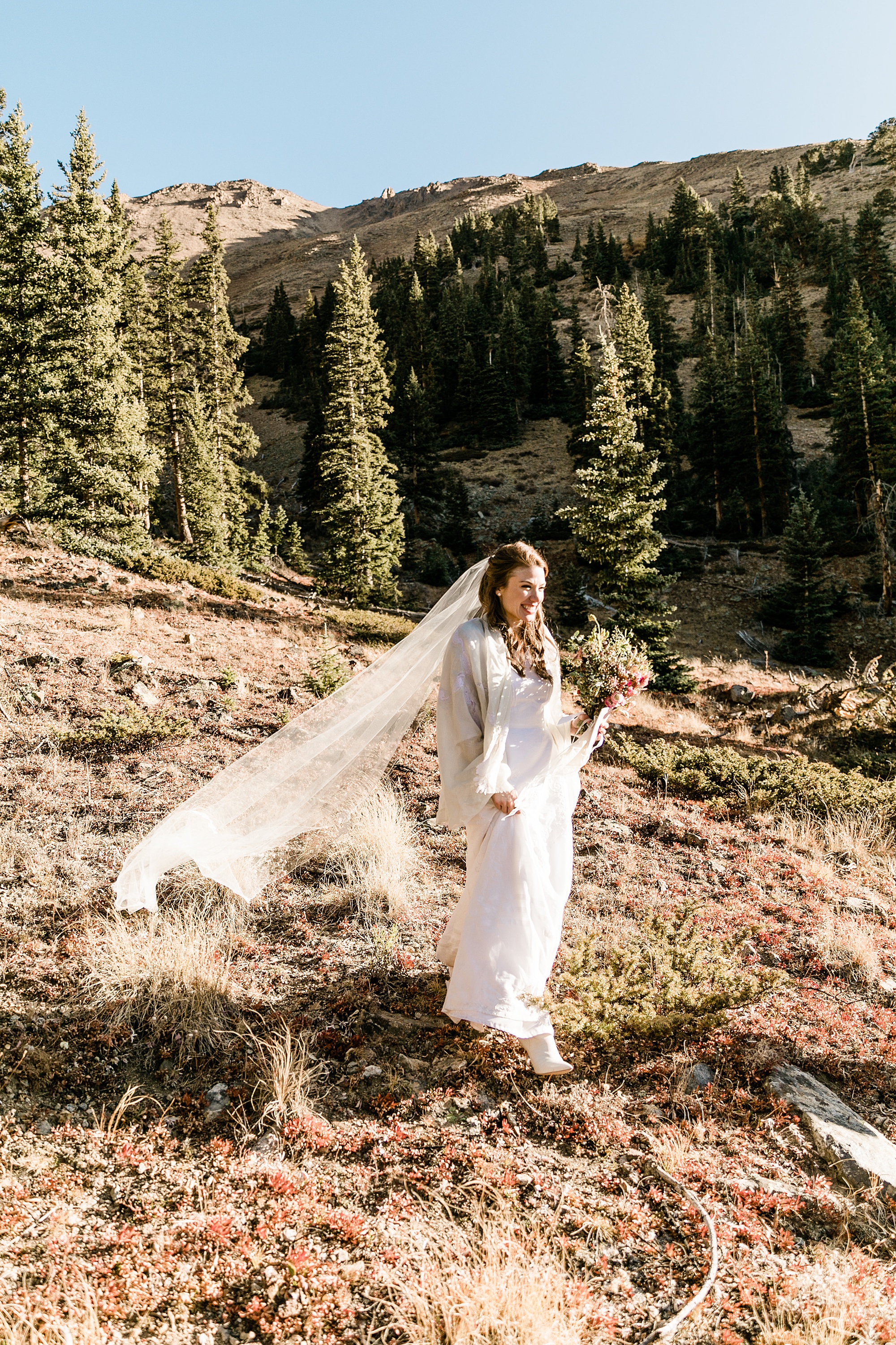 bride walking down the mountain toward groom