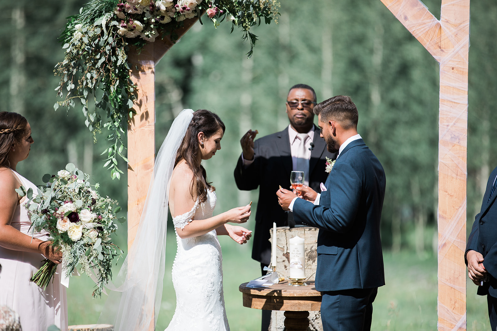bride and groom have communion at Silverpick Lodge summer outdoor wedding