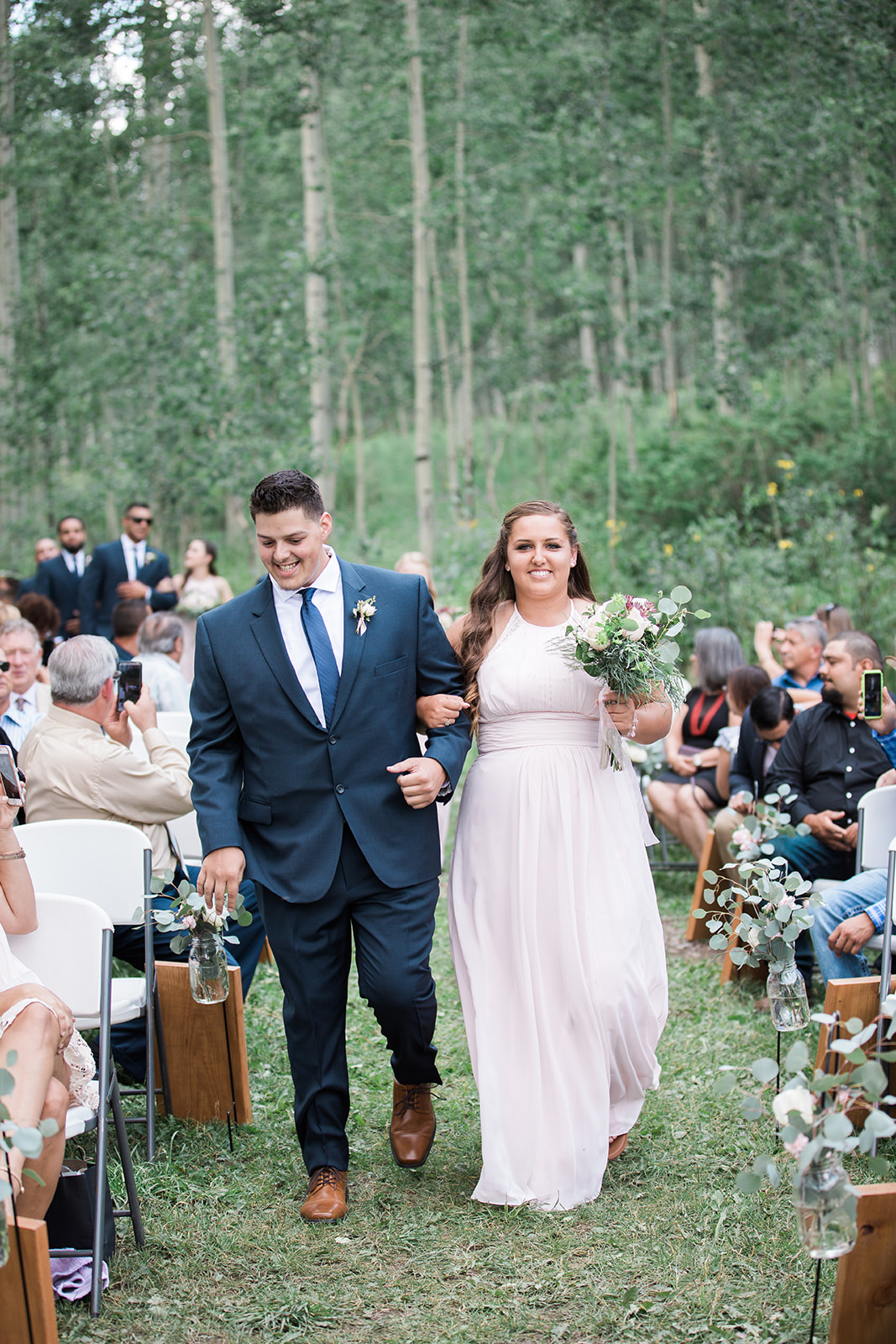 bridesmaid and groomsman walk down the aisle at Silverpick Lodge outdoor Colorado wedding