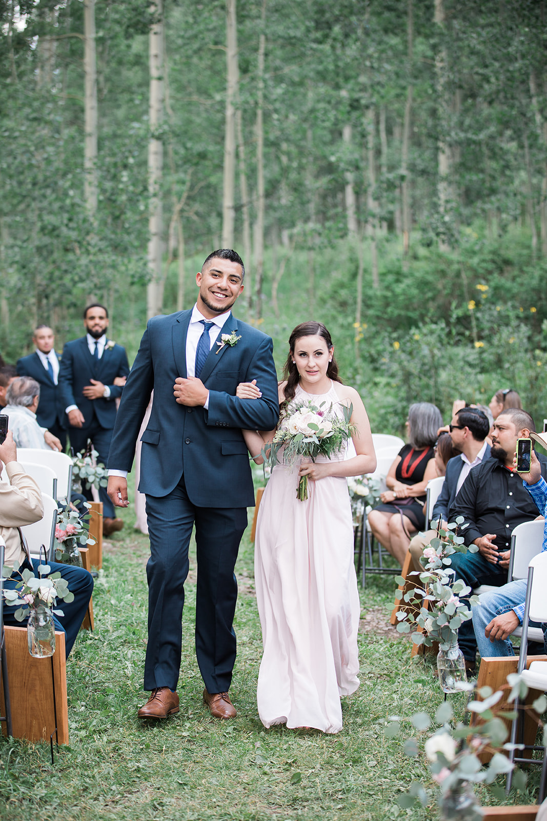 bridesmaid and groomsman walk down the aisle at Silverpick Lodge outdoor Colorado wedding