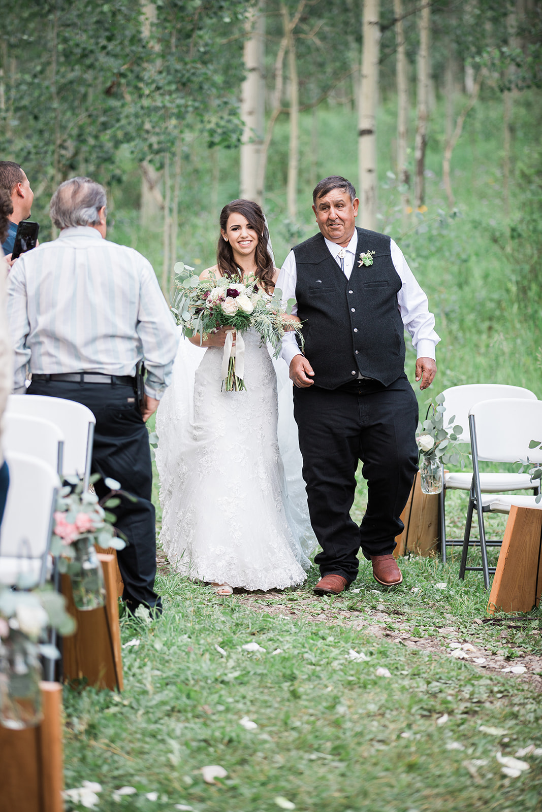 bride and father walk down aisle in outdoor Durango wedding ceremony