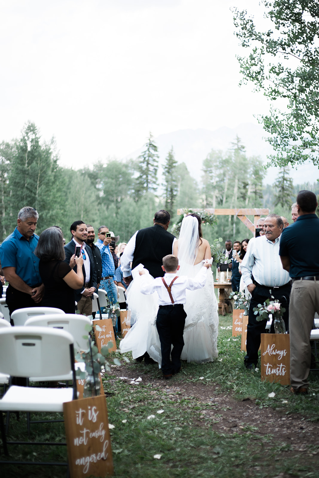 bride and father walk down aisle in Silverpick Lodge outdoor Durango wedding ceremony