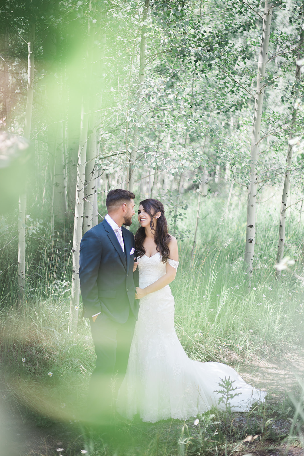 bride and groom standing in woods