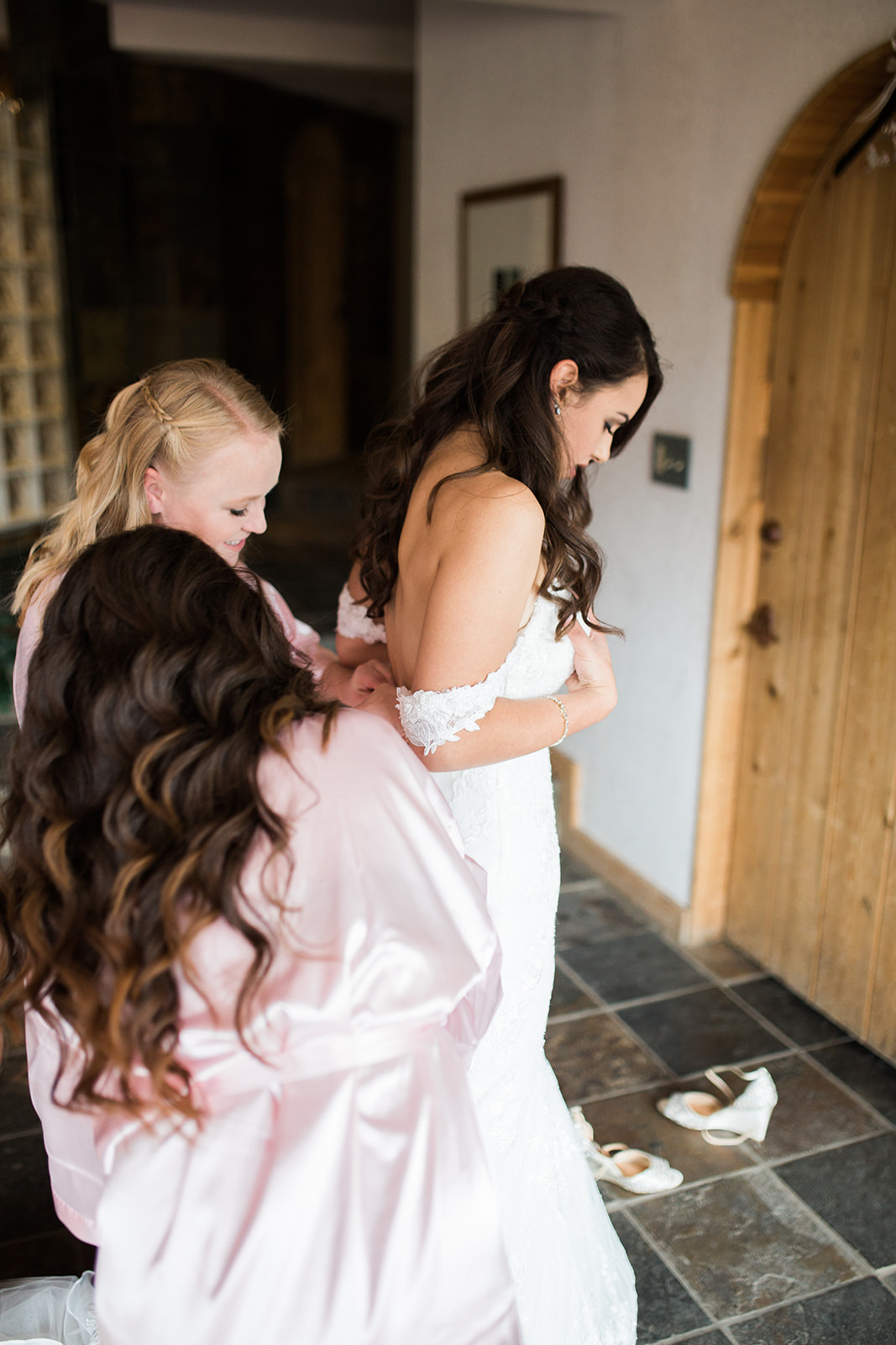 bride gets into dress at Silverpick Lodge in Durango Colorado