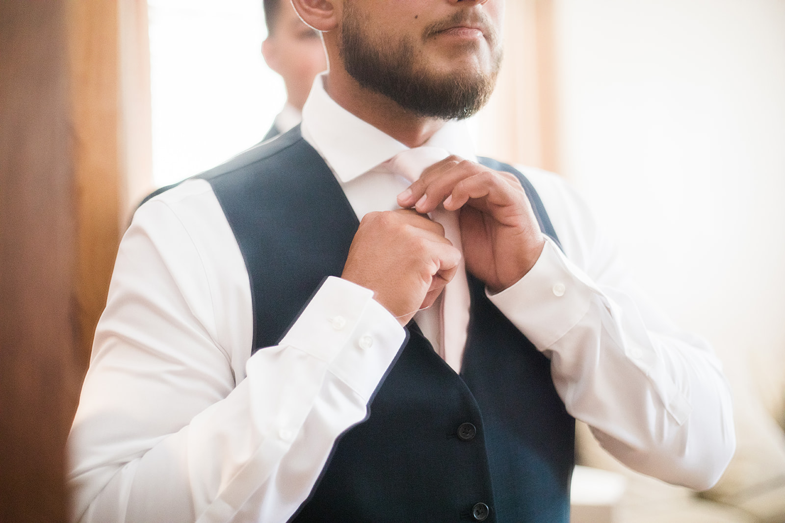 groom tightening tie to get ready for Silverpick Lodge Durango wedding