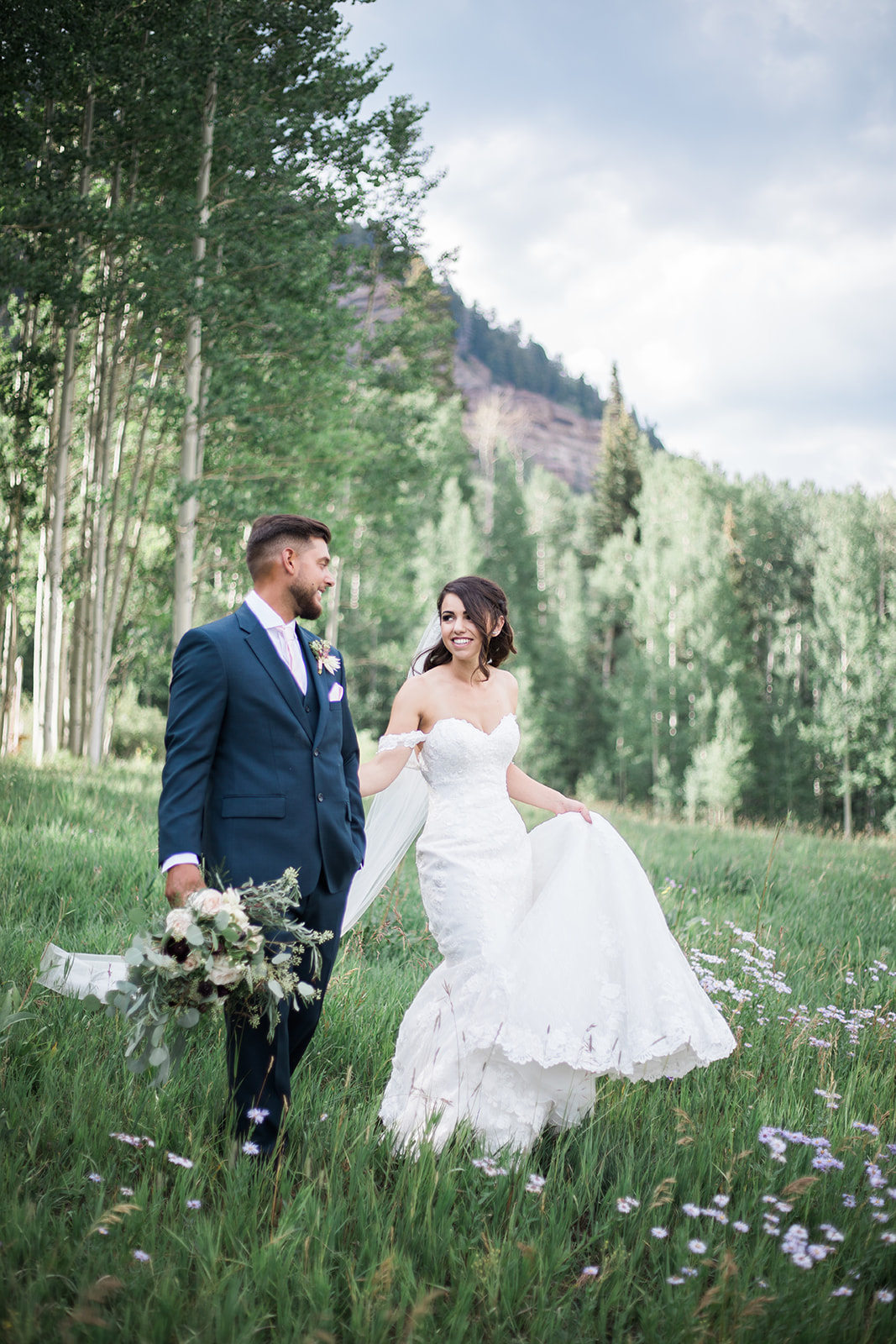 groom kisses bride in alpine field in Durango Colorado