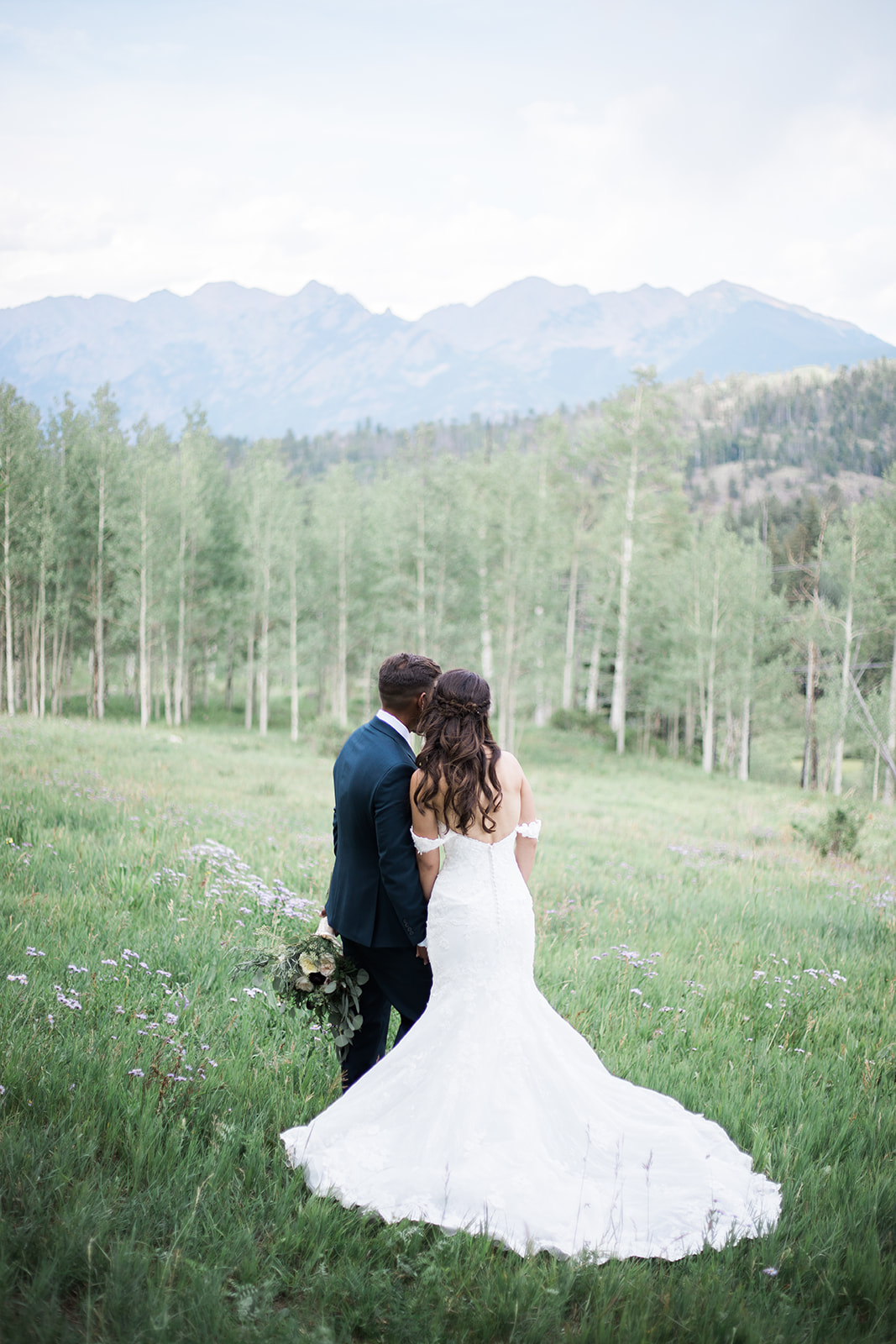 groom kisses bride in alpine field in Durango Colorado