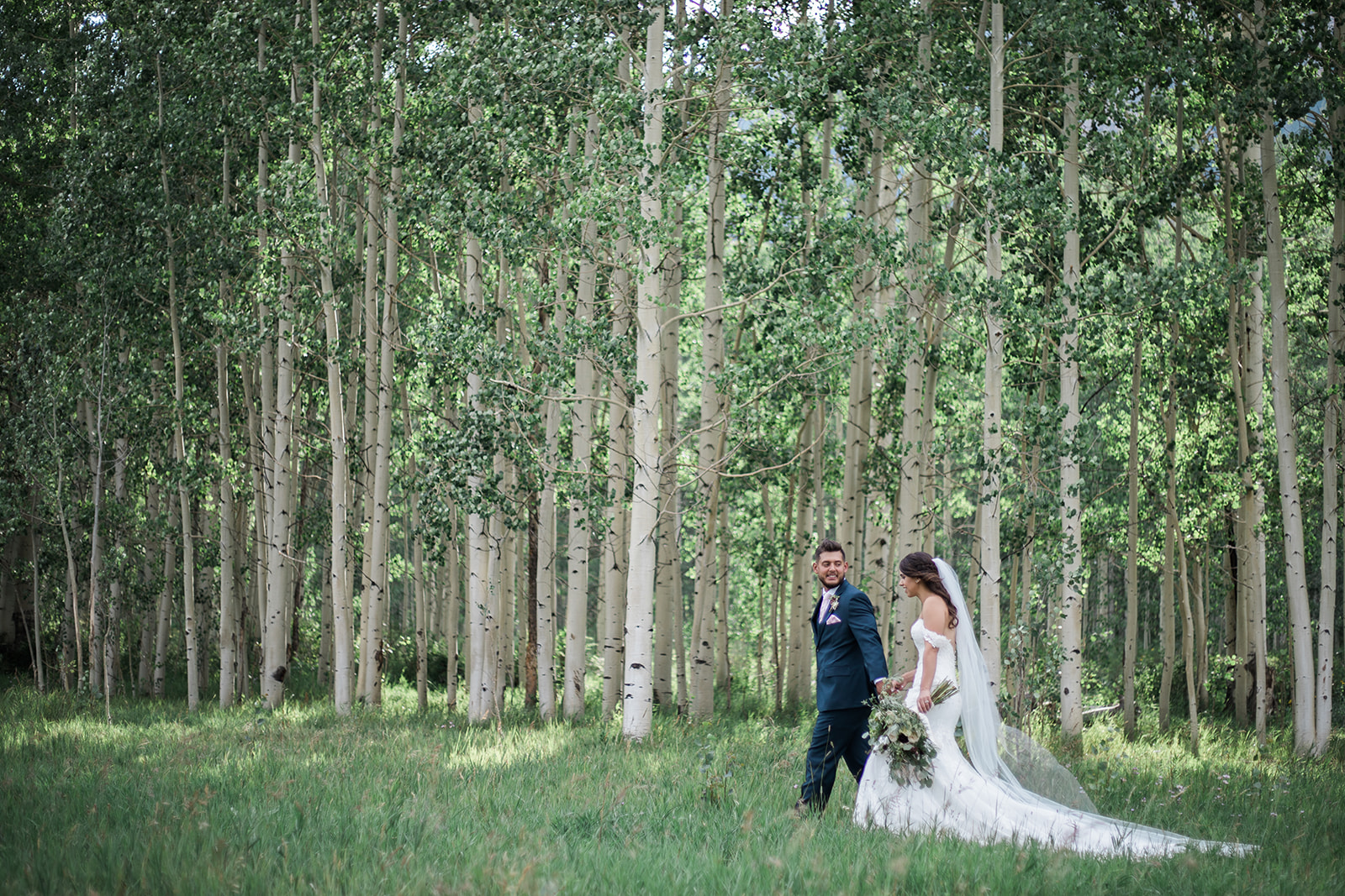 bride and groom walking in Durango Colorado woods
