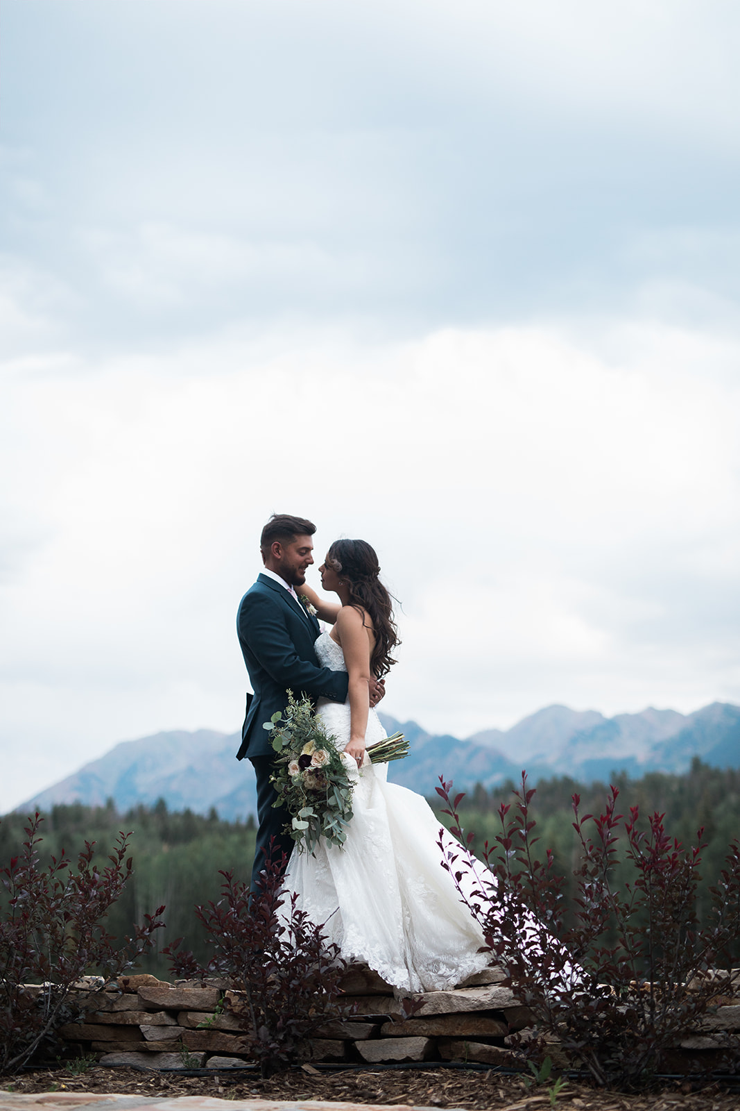 bride and groom in front of dramatic Silverpick Lodge mountain vista