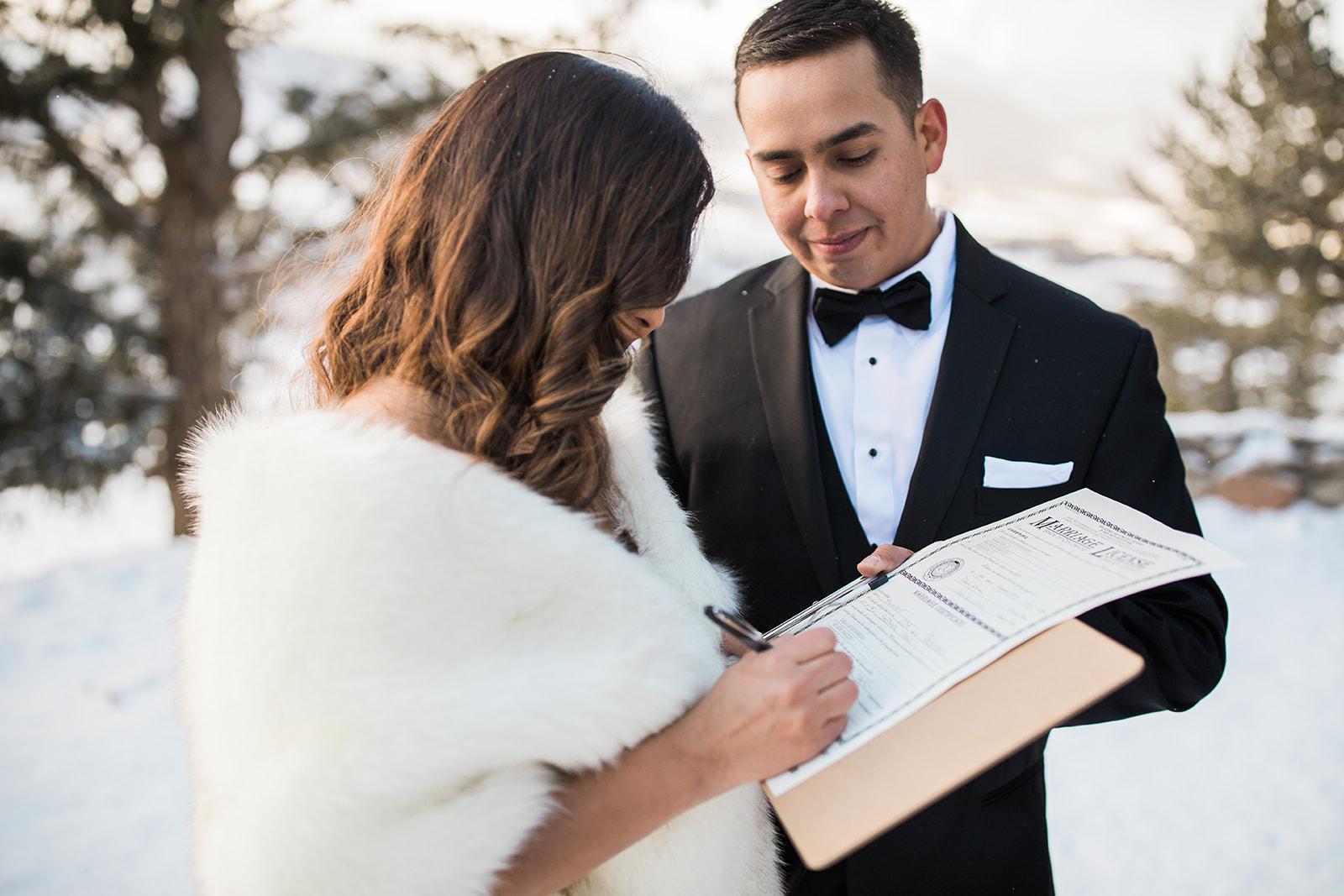 bride and groom sign marriage license after elopement