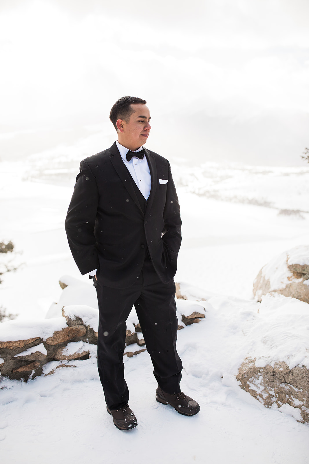 groom portrait in front of snowy Colorado mountain vista