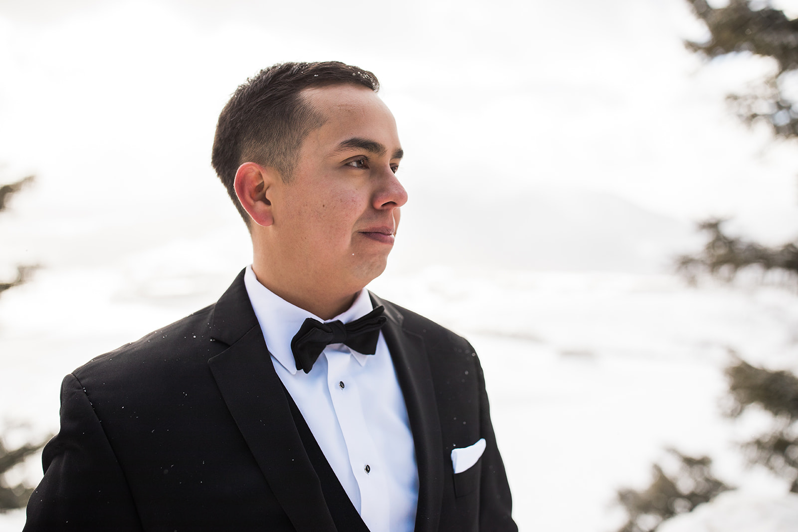 groom portrait in front of snowy Colorado mountain vista