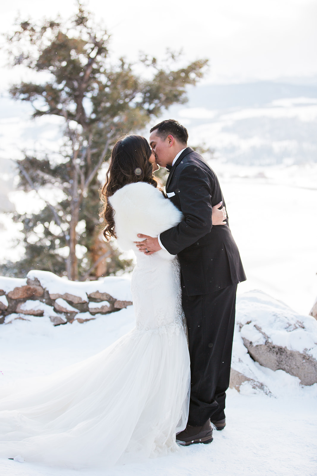 first kiss in front of of snowy Colorado mountain backdrop