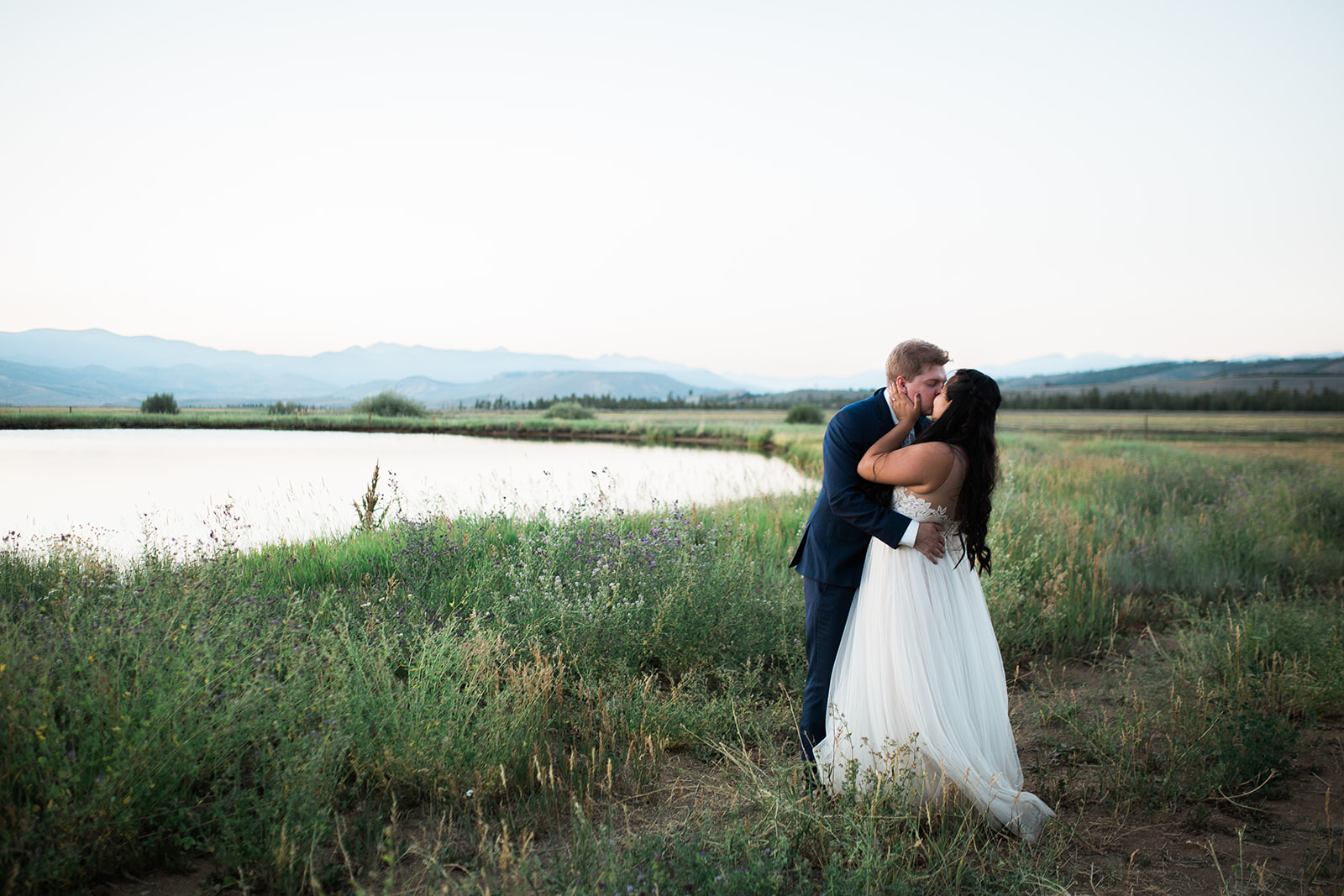 couple kissing near a lake at the Crestview Ranch in Granby Colorado
