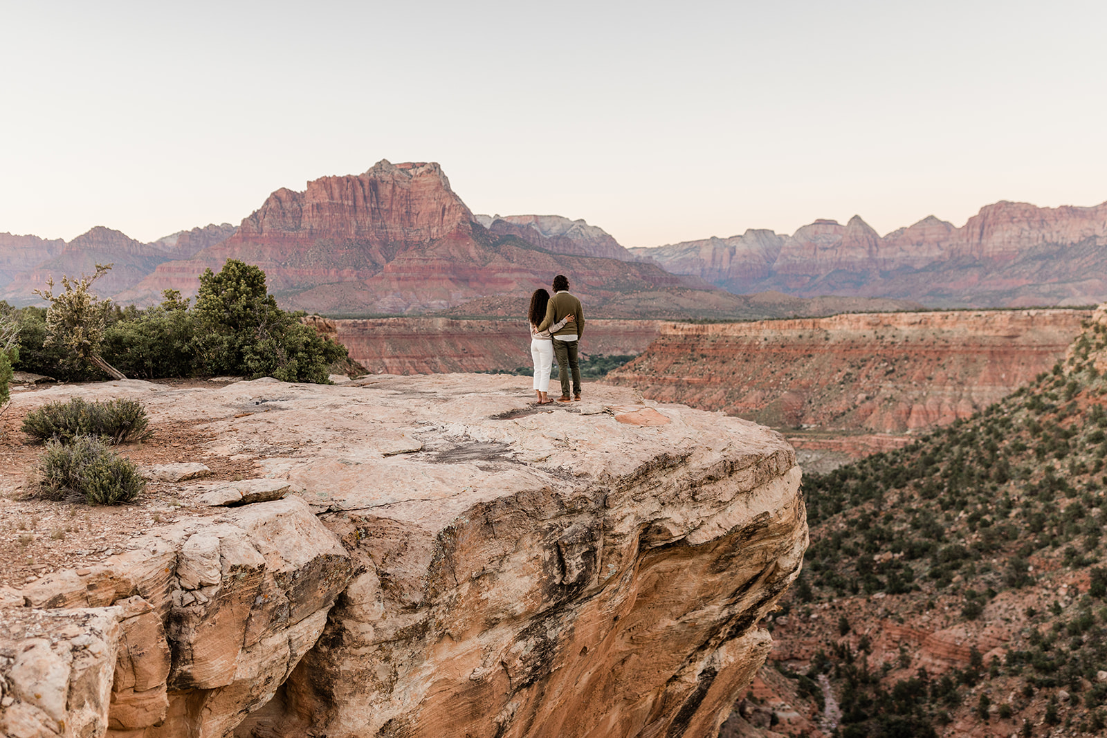 engaged couple looks out over Zion National Park