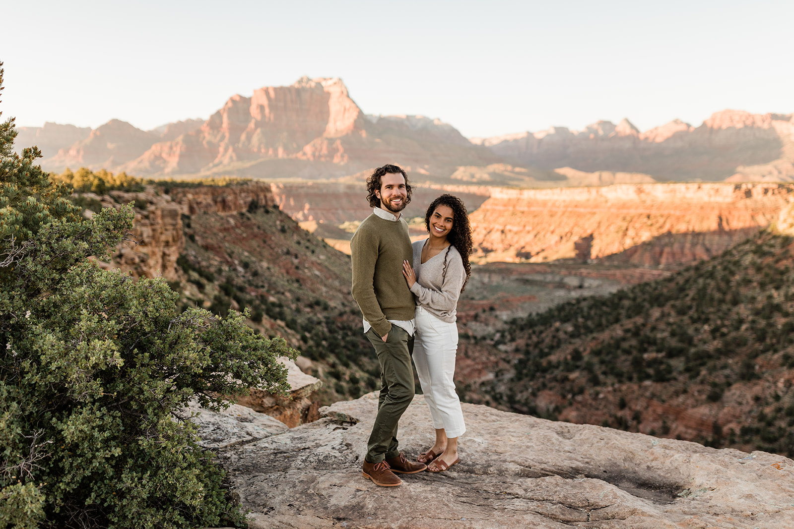 couple poses in front of dramatic Zion National Park vista