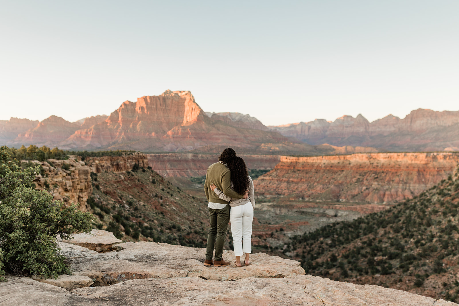 couple poses in front of dramatic Zion National Park vista