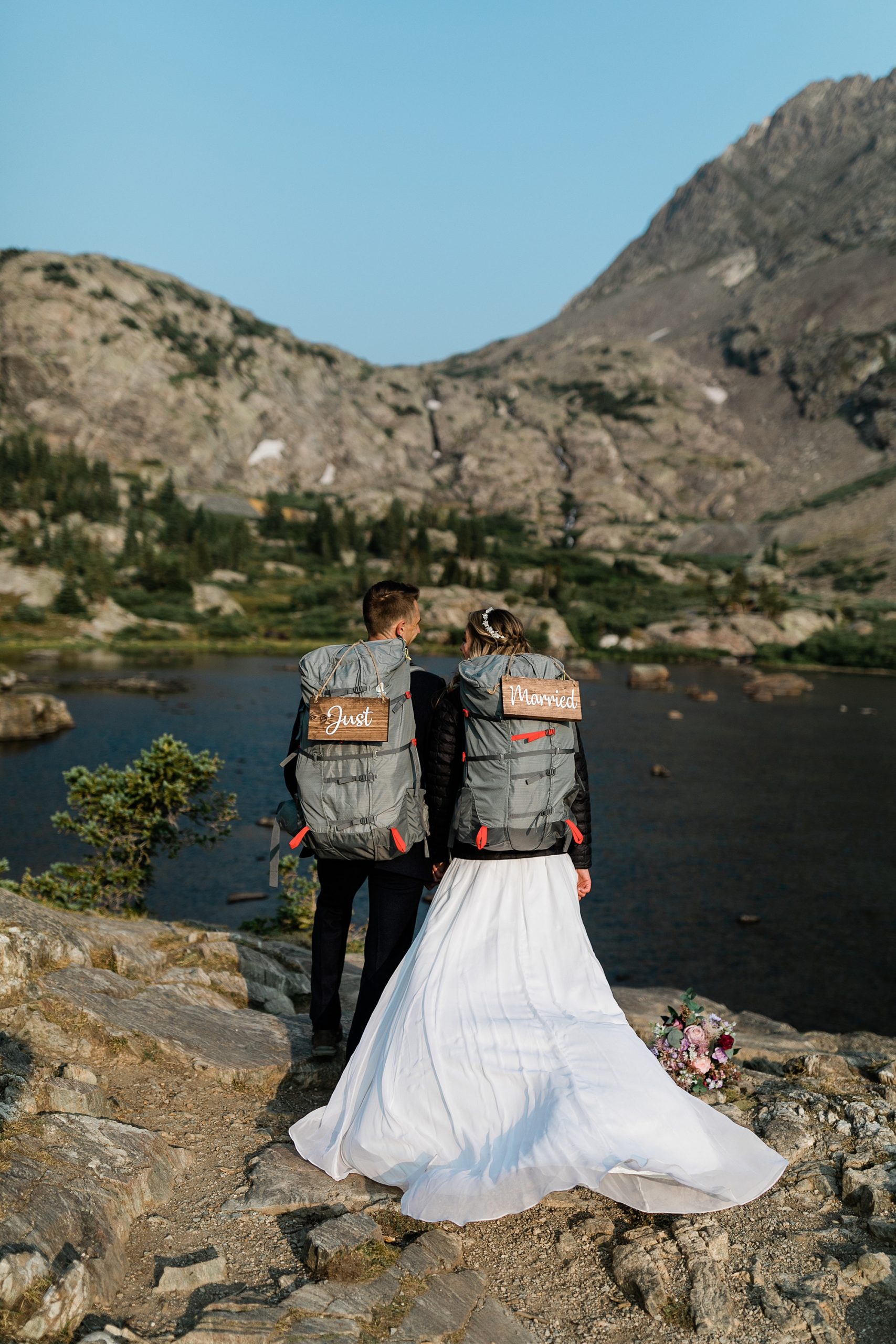 just married signs on back packs after hiking elopement in colorado